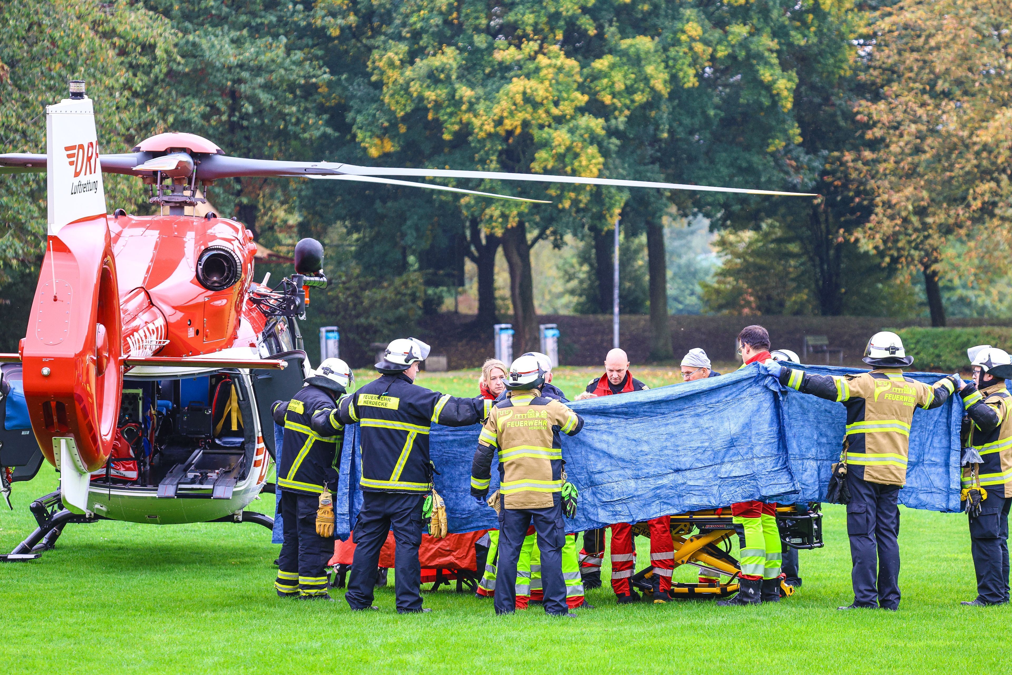 Einsatzkräfte stehen neben einem Rettungshubschrauber. Die neu gewählte Bürgermeisterin von Herdecke, Iris Stalzer (SPD), war im Oktober 2025 lebensgefährlich verletzt in ihrer Wohnung gefunden worden. (Archivbild)