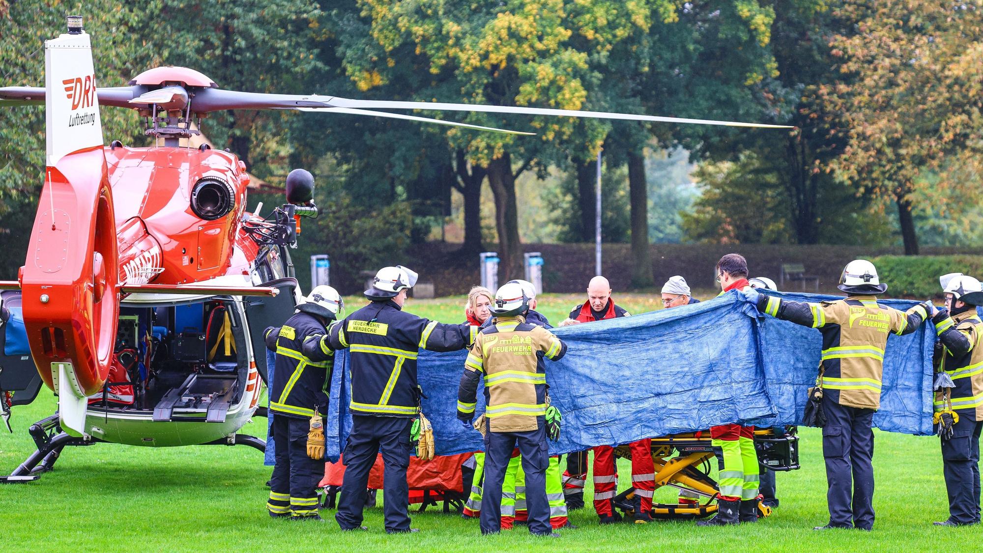 Einsatzkräfte stehen neben einem Rettungshubschrauber. Die neu gewählte Bürgermeisterin von Herdecke, Iris Stalzer (SPD), war im Oktober 2025 lebensgefährlich verletzt in ihrer Wohnung gefunden worden. (Archivbild)