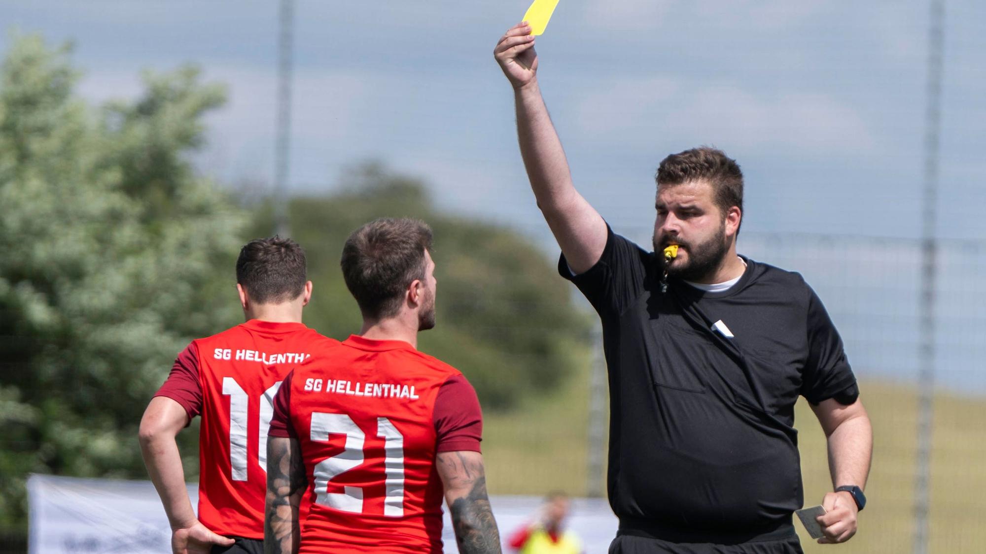 Der Schiedsrichter gibt einem Hellenthaler Spieler die Gelbe Karte.