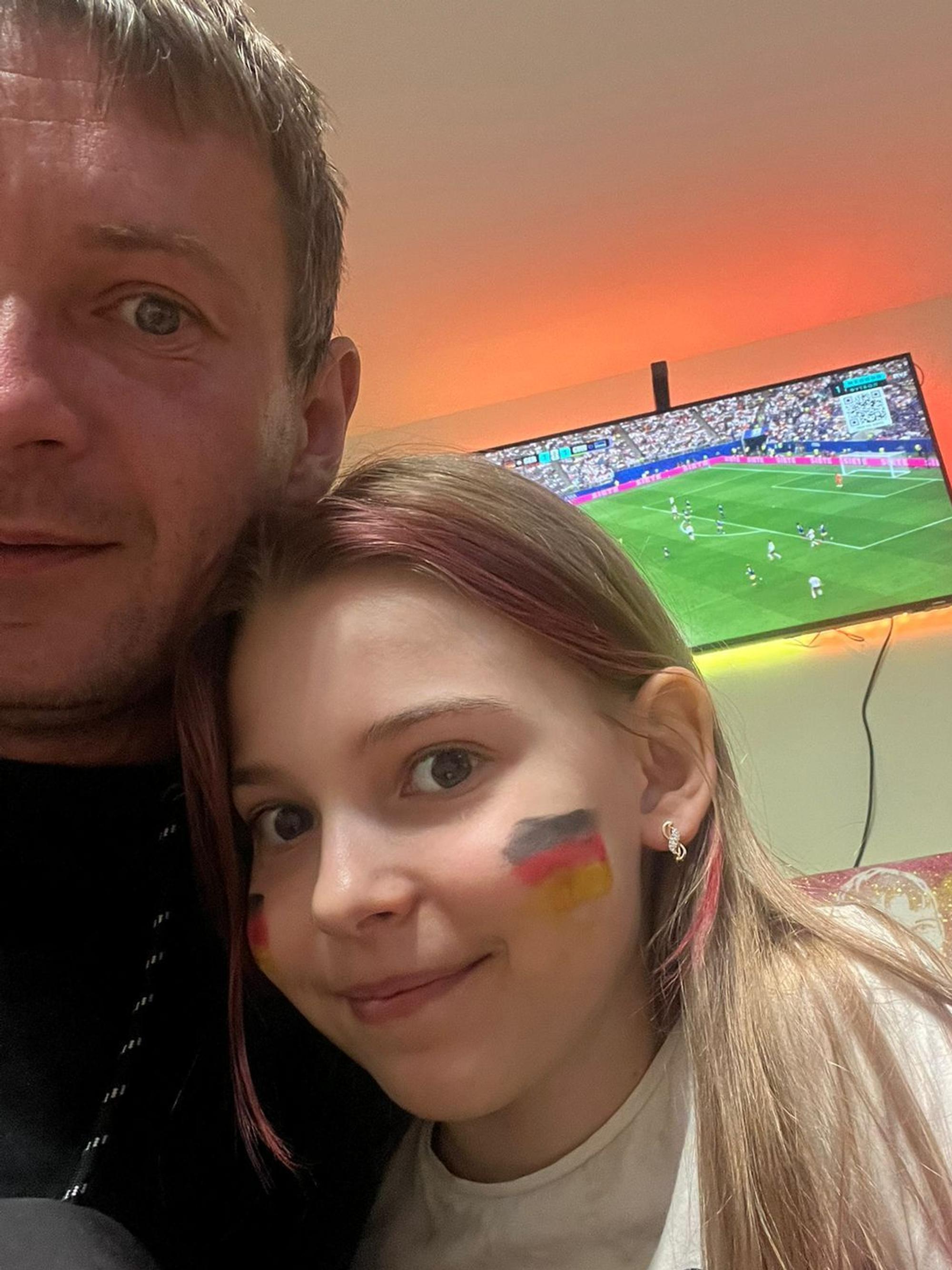 Dima Jaroschewytsch schaut mit seiner Tochter das Spiel von Deutschland gegen Curacao