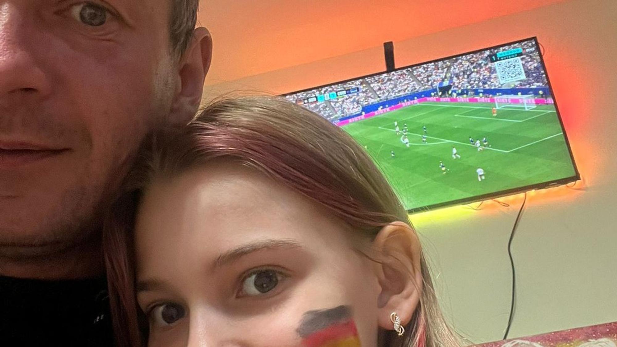 Dima Jaroschewytsch schaut mit seiner Tochter das Spiel von Deutschland gegen Curacao