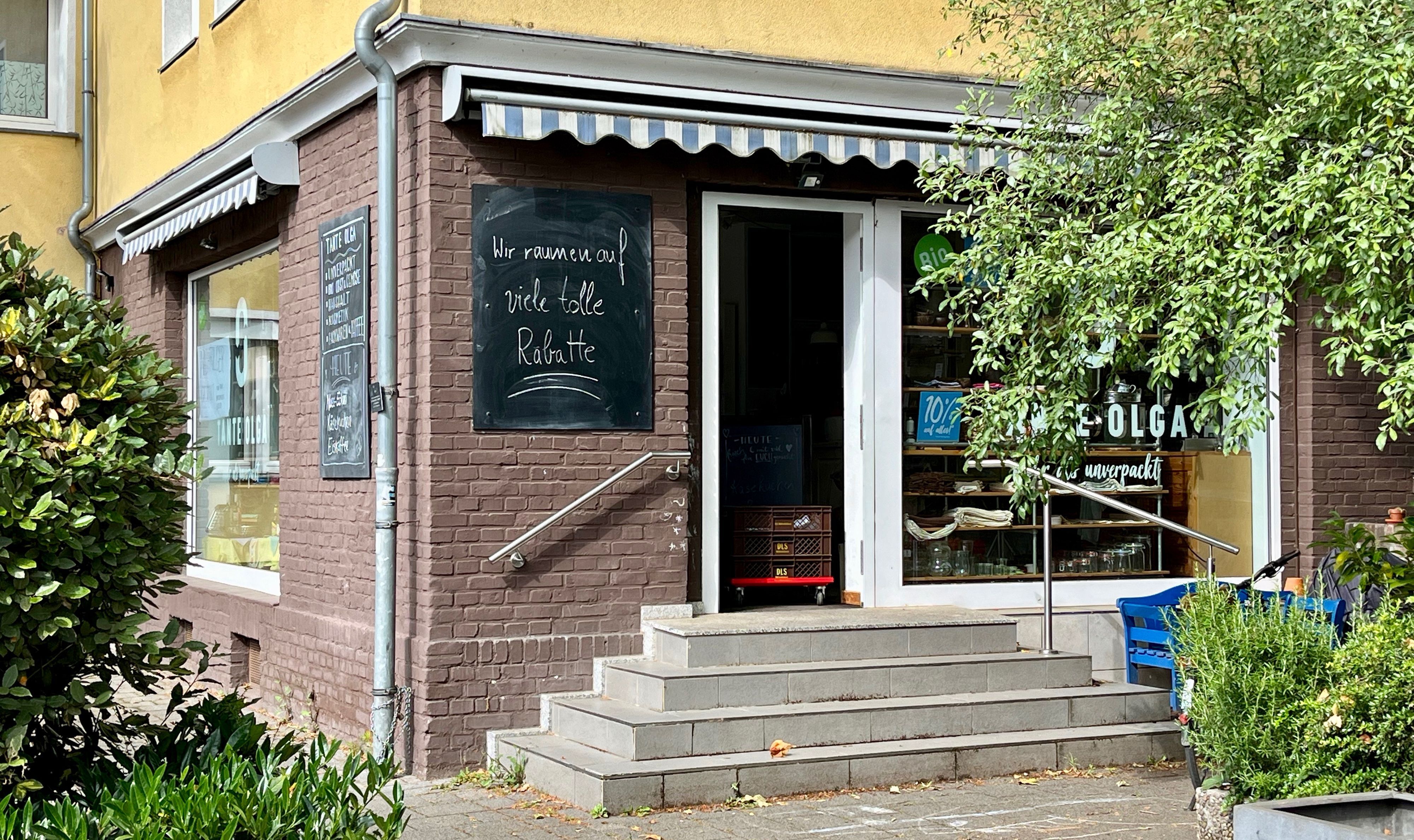 Ein kleines Eckladen-Lokal mit einer Treppe zur Eingangstür ist zu sehen.