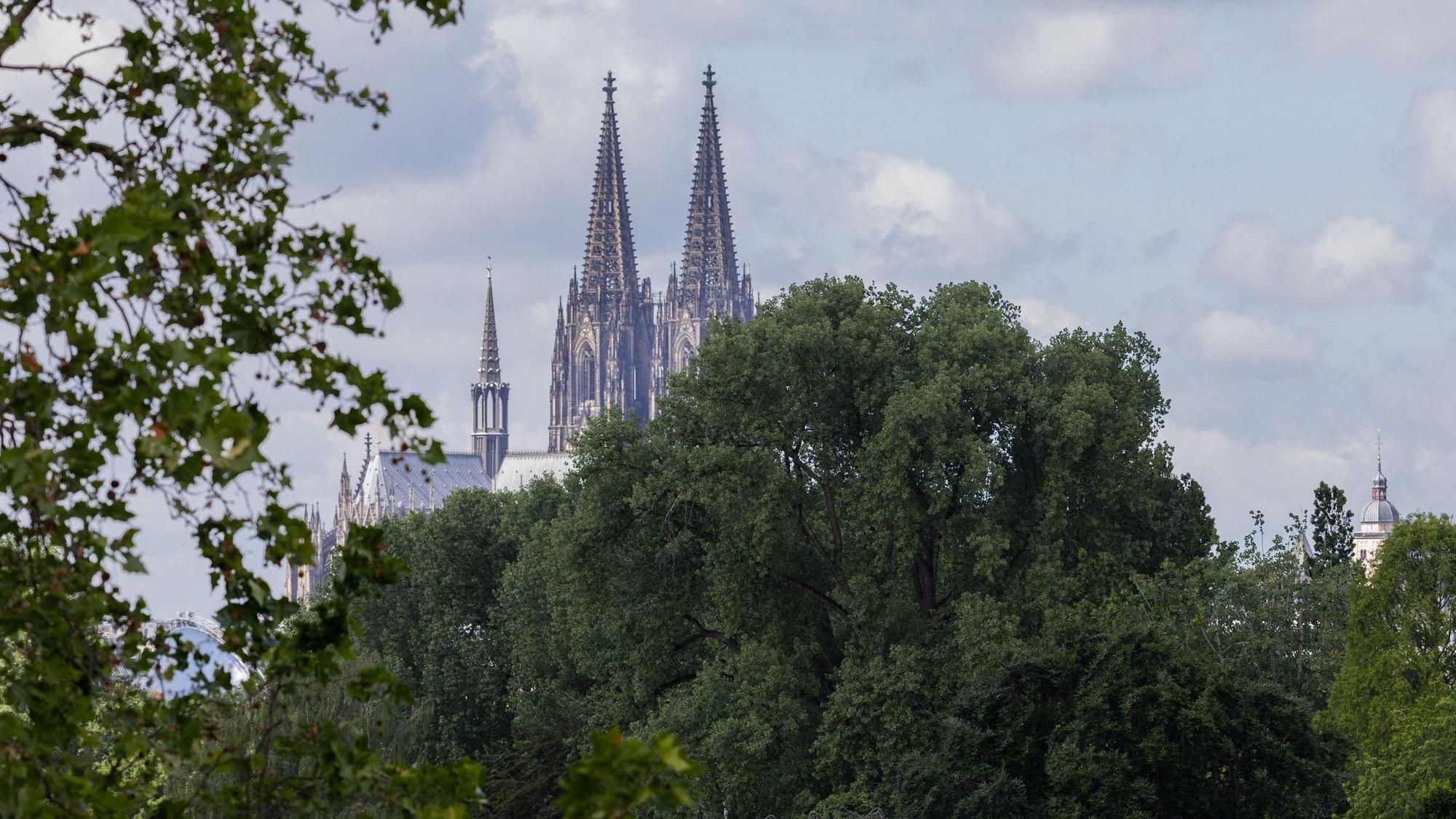 09.06.2026, Nordrhein-Westfalen, Köln: Die Kleinbahn im Rheinpark fährt bei wechselhaftem Wetter vor der Kulisse des Doms. Foto: Rolf Vennenbernd/dpa +++ dpa-Bildfunk +++