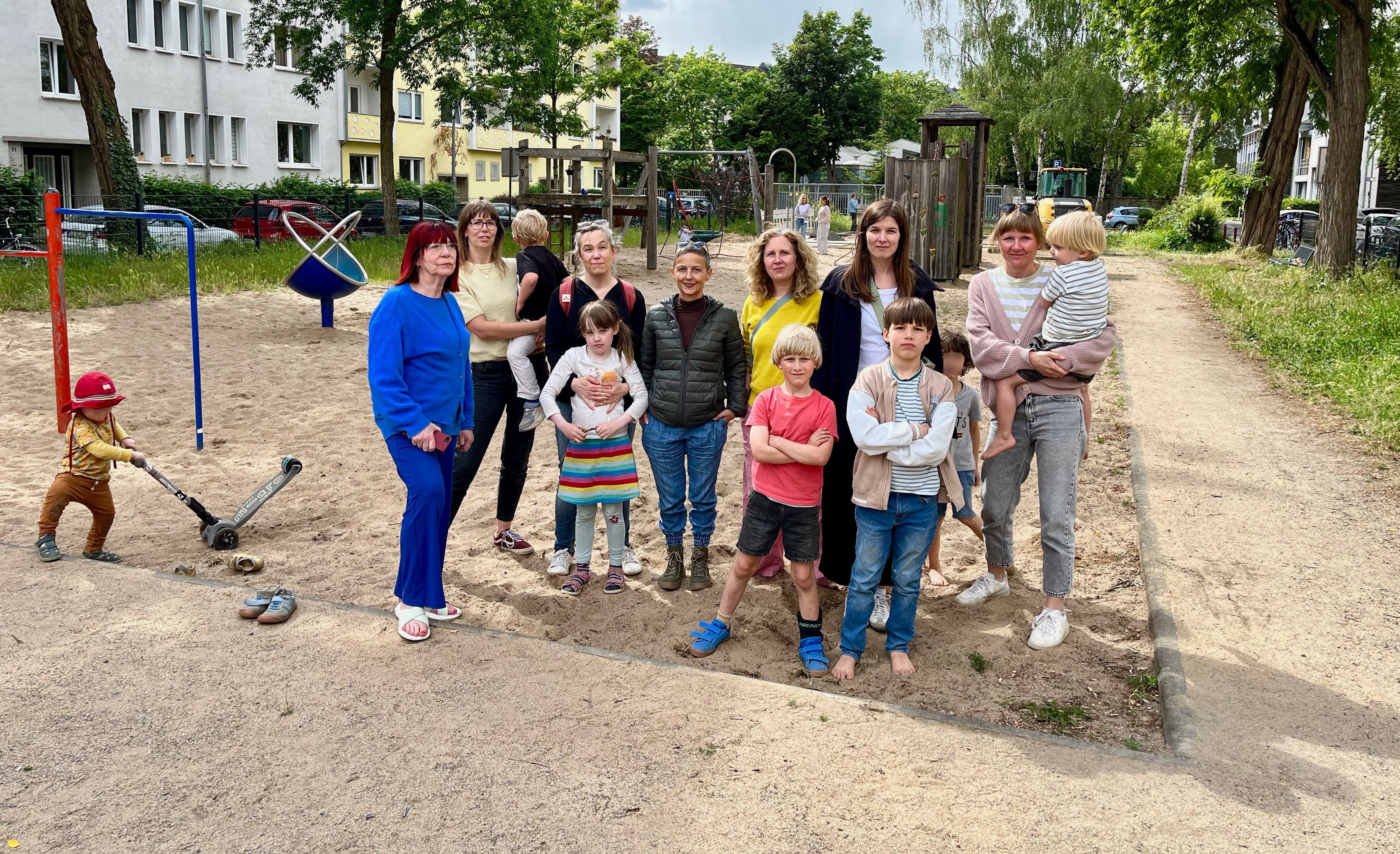 Anwohnerinnen und ihre Kinder auf dem Spielplatz Münstereifeler Platz. Auf dem Areal vor dem Sandkasten, an dem sie stehen, sollen die Container aufgestellt werden.