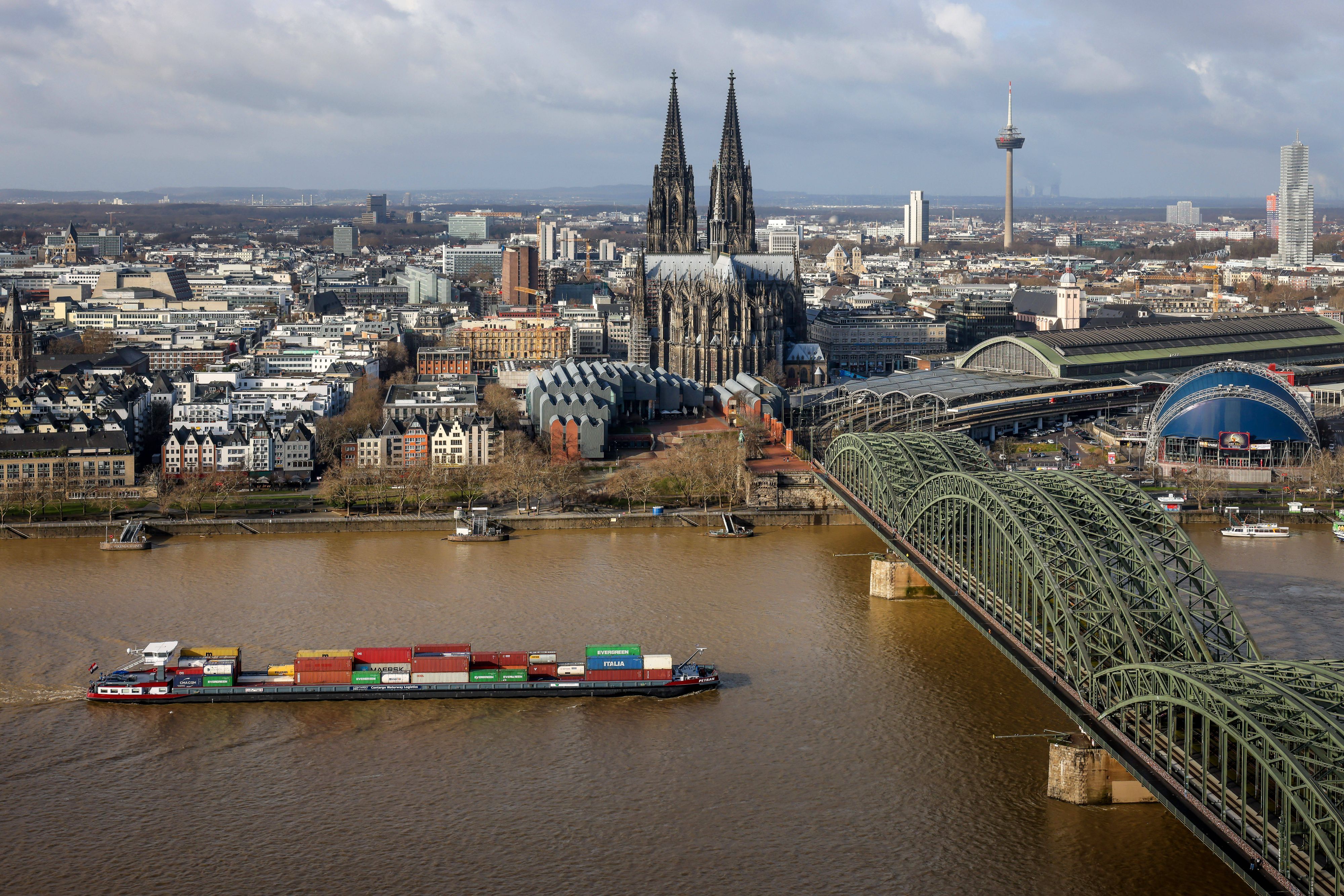 Koeln, Nordrhein-Westfalen, Deutschland - Stadtansicht mit Kölner Dom, der Hohenzollernbrücke und Containerschiff auf dem Rhein. Koeln Nordrhein-Westfalen Deutschland