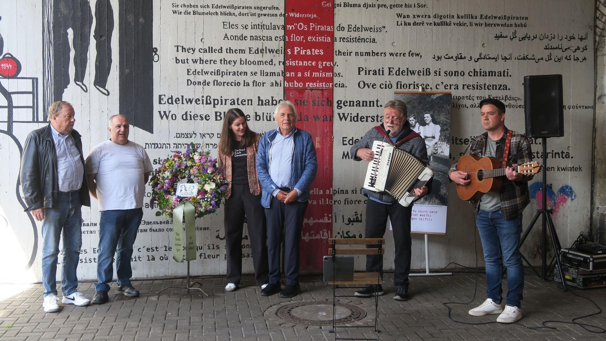 Fünf Männer und eine Frau stehen am Denkmal für die Edelweißpiraten in Köln-Ehrenfeld.