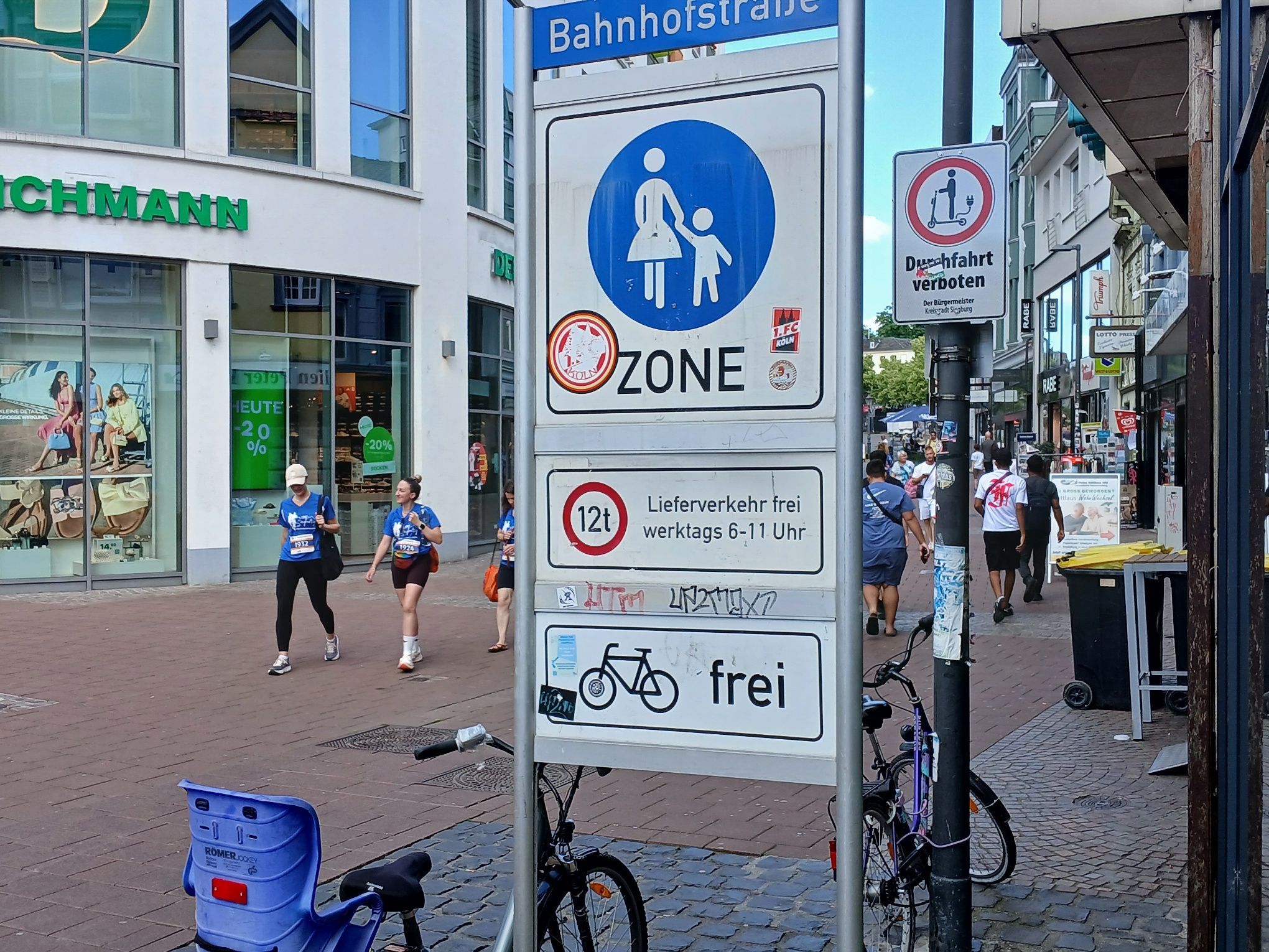 Verkehrsschilder an der Siegburger Fußgängerzone: Die große Tafel verdeckt das Verbot für E-Roller.