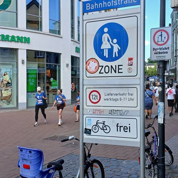 Verkehrsschilder an der Siegburger Fußgängerzone: Die große Tafel verdeckt das Verbot für E-Roller.