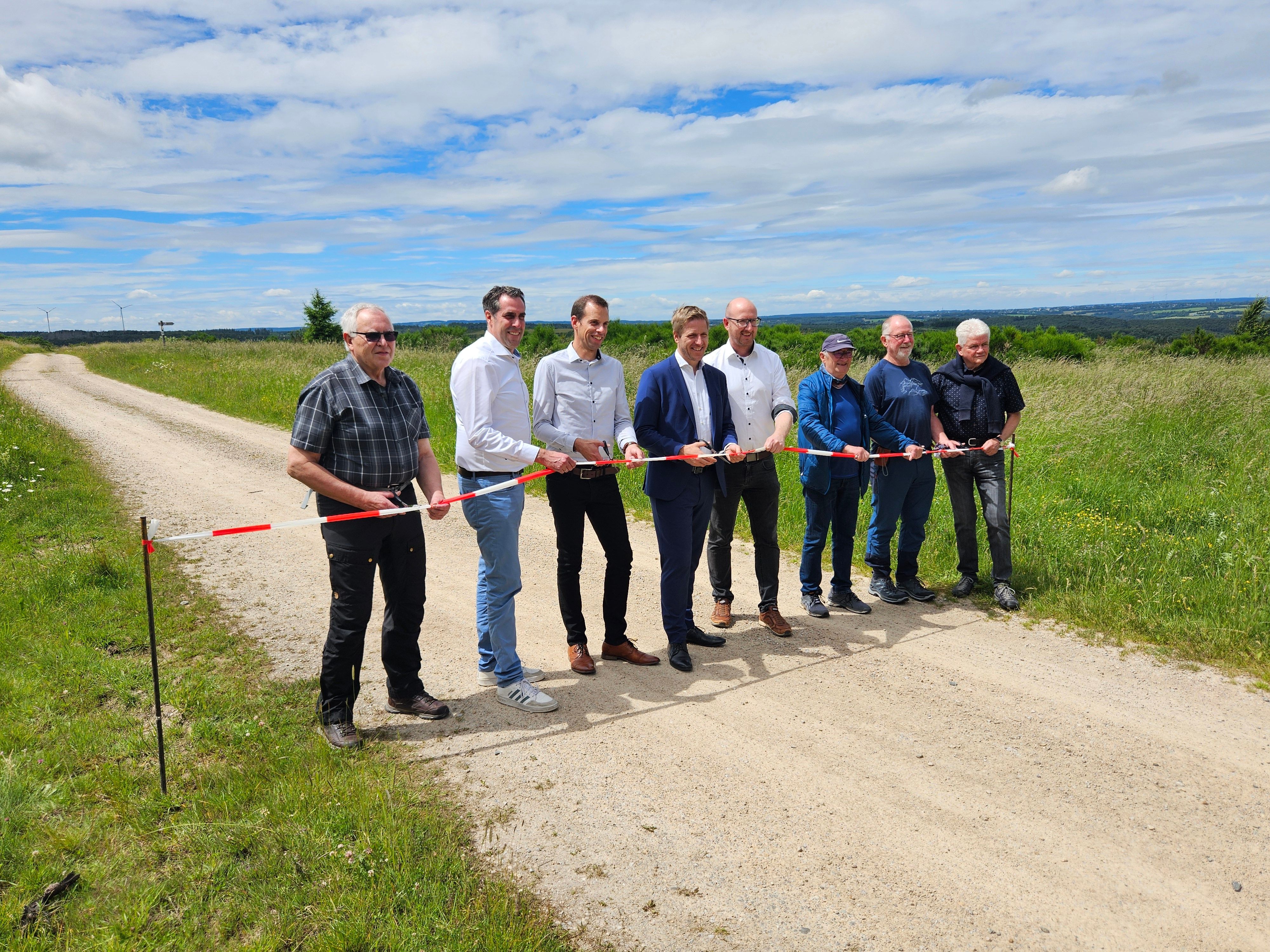 Die Genannten stehen auf einem Weg nebenneinander und zerschneiden ein Flatterband.