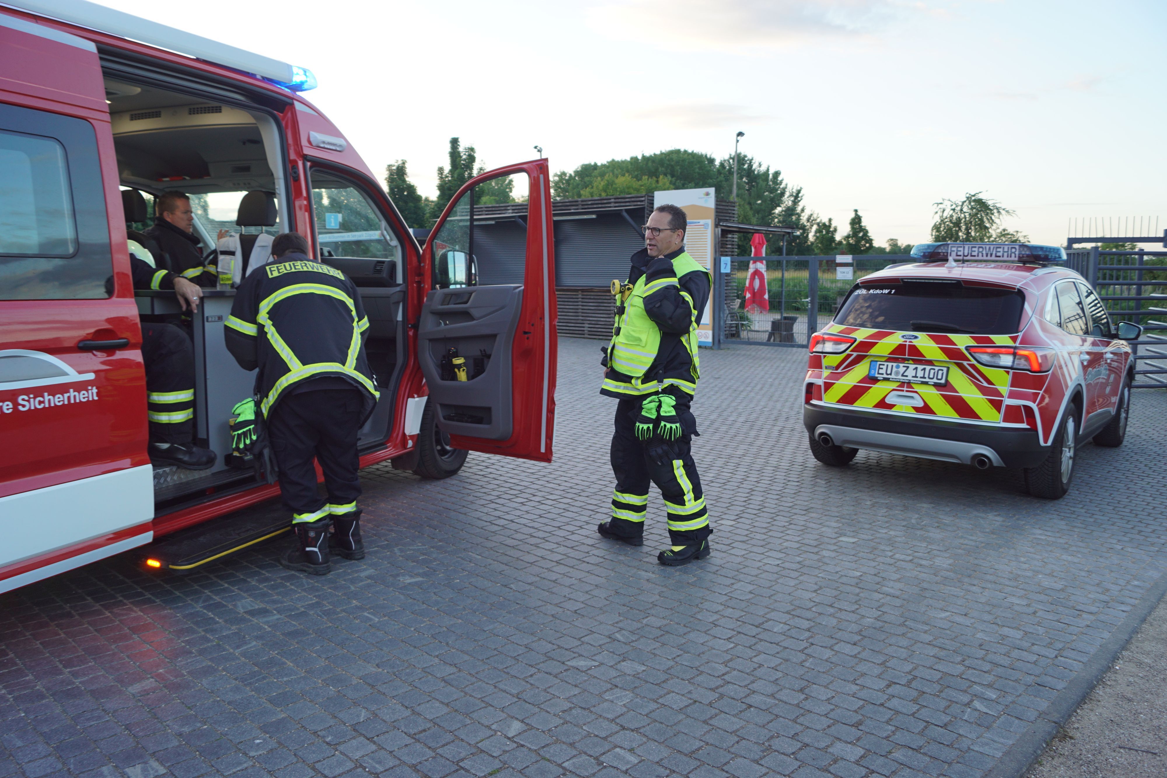 Einsatzkräfte der Feuerwehr Zülpich stehen an zwei Fahrzeugen.