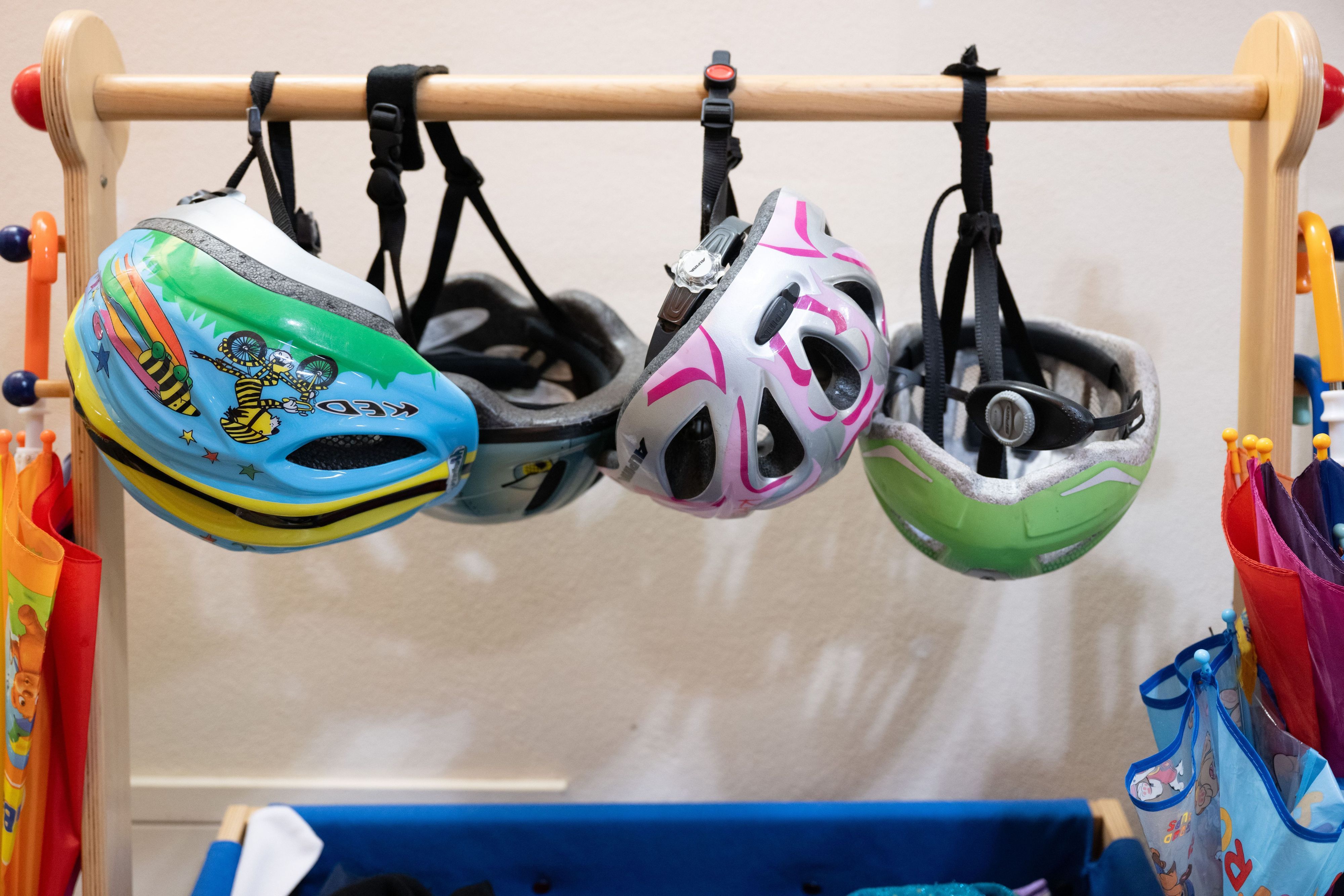Fahrradhelme hängen in einer Garderobe in einer Kita. (Symbolbild)