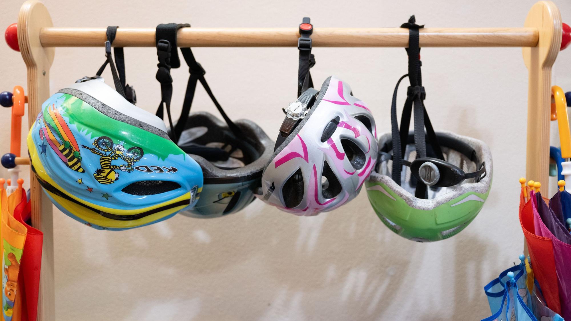 Fahrradhelme hängen in einer Garderobe in einer Kita. (Symbolbild)