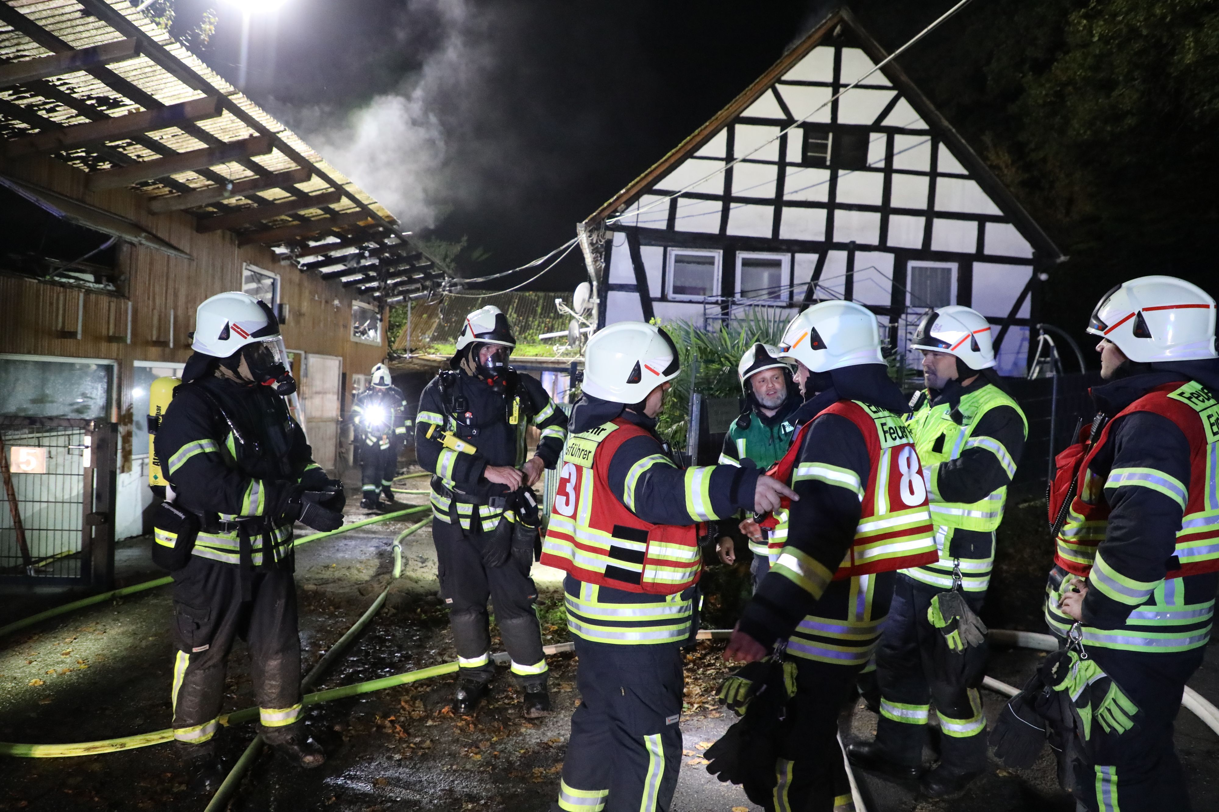 Feuerwehrleute sind bei einem Brand an einem Fachwerkhaus.