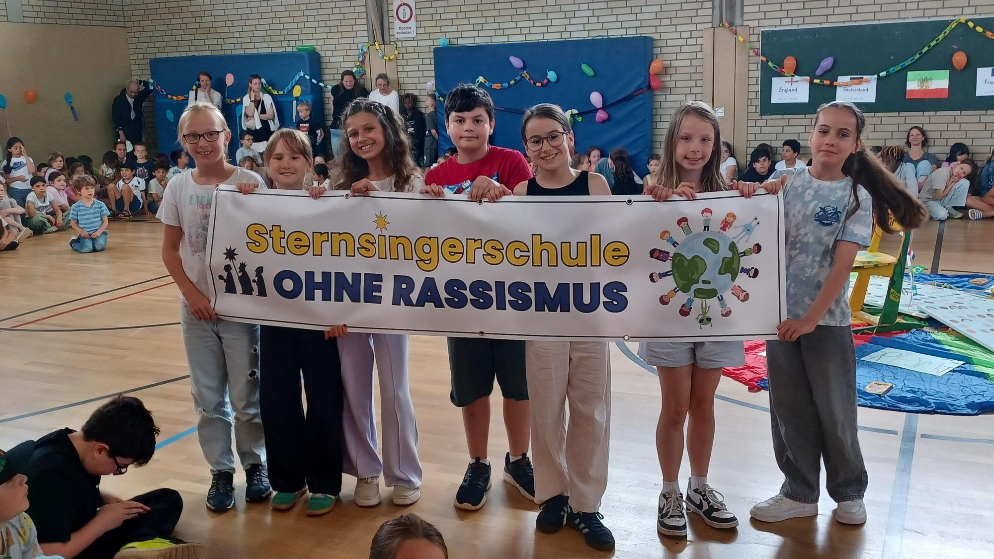 Eine Gruppe von Kindern trägt das Transparent zur Aktion durch die Halle.