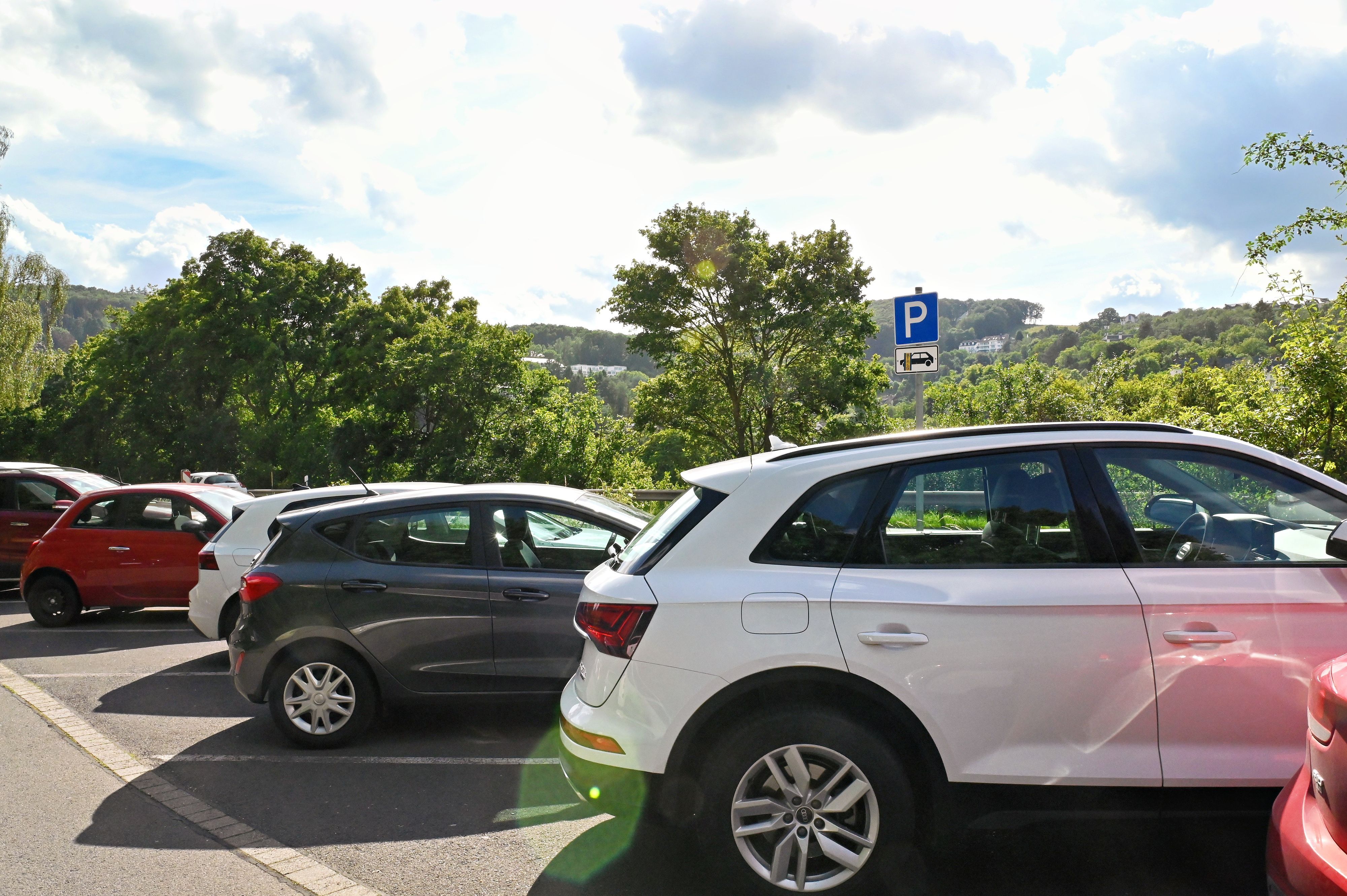 Autos stehen auf einem Parkplatz. Im Hintergrund ist das Parkplatz-Schild mit dem Zusatz-Piktorgramm "nur für Pkw" zu erkennen.