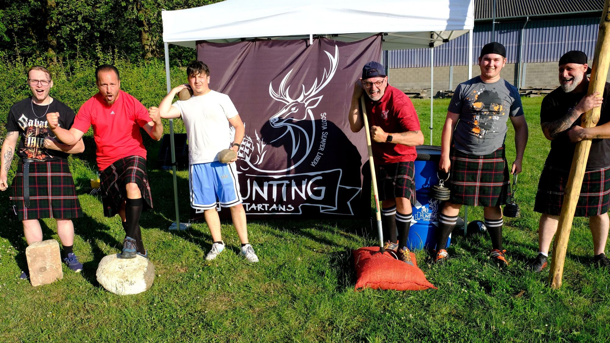 Die Sportler der Hunting Tartans laden auf dem Bolzplatz in Hostel zum Training für die Highland-Games ein. Einige tragen schottische Kilts.