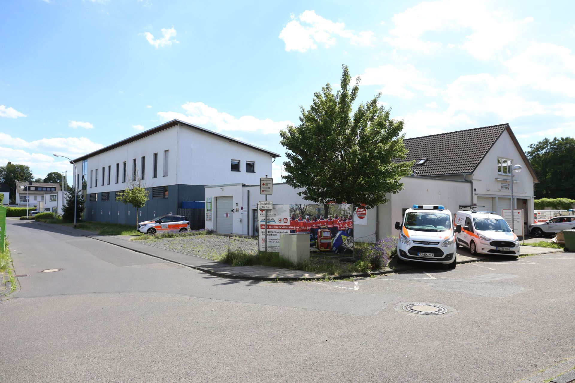 Mehrere Gebäude mit Einsatzfahrzeugen davor.