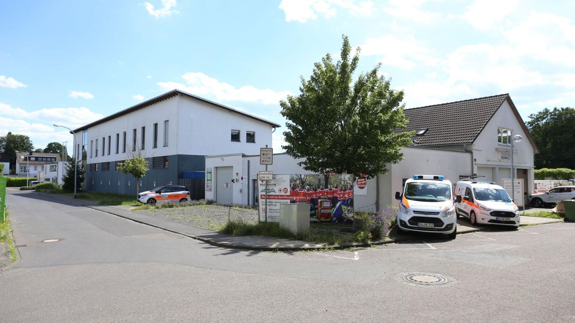 Mehrere Gebäude mit Einsatzfahrzeugen davor.