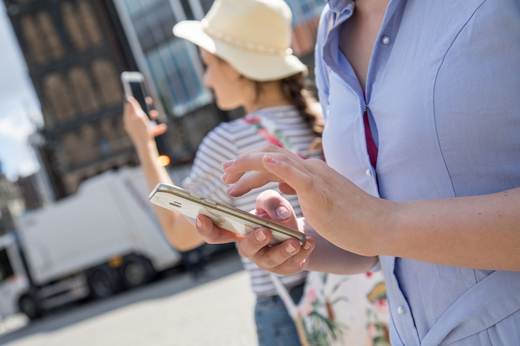 Urlauberinnen schauen auf ihre Smartphones