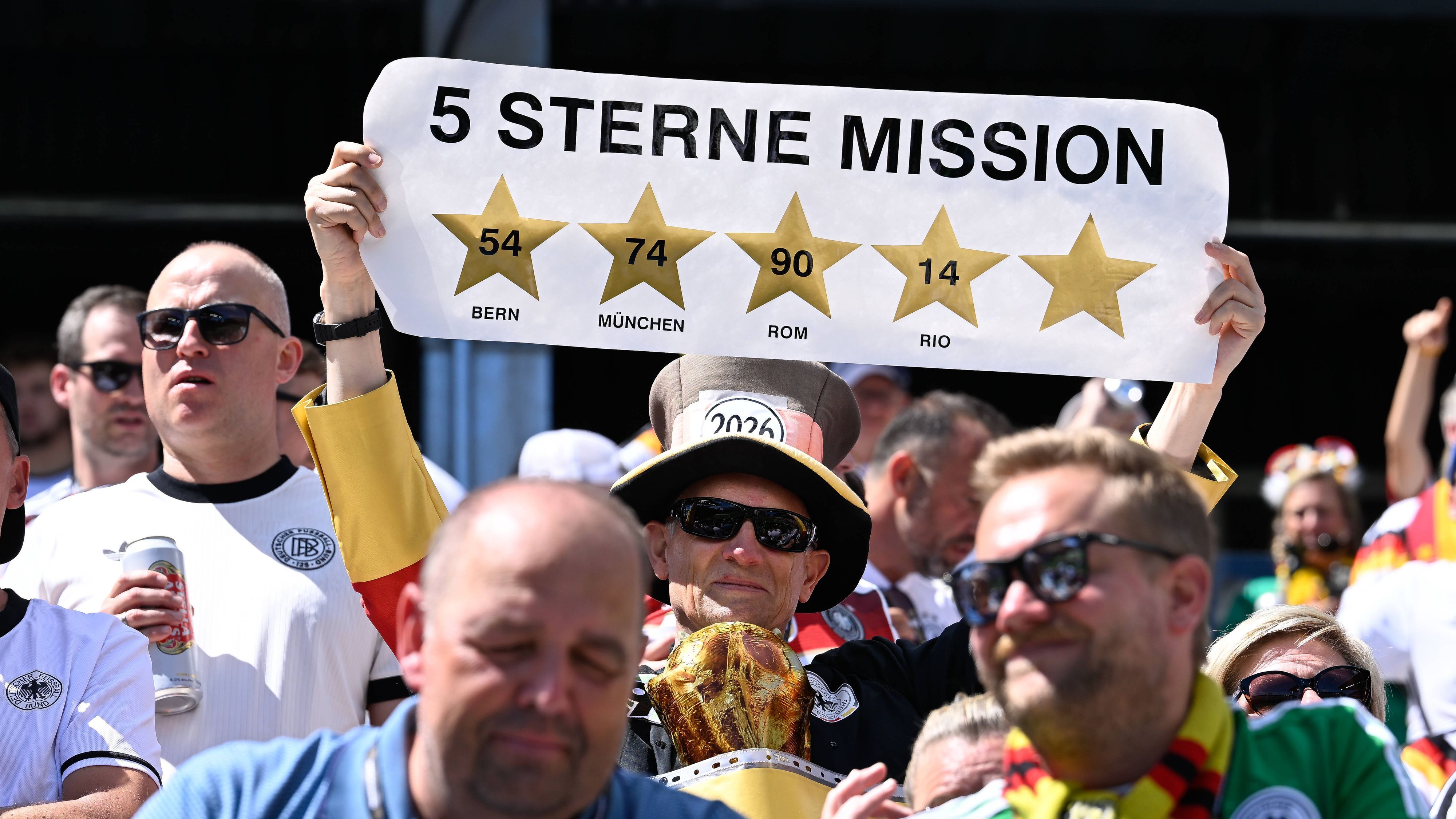 Ein deutscher Fan hält ein Schild „5 Sterne Mission“ hoch.