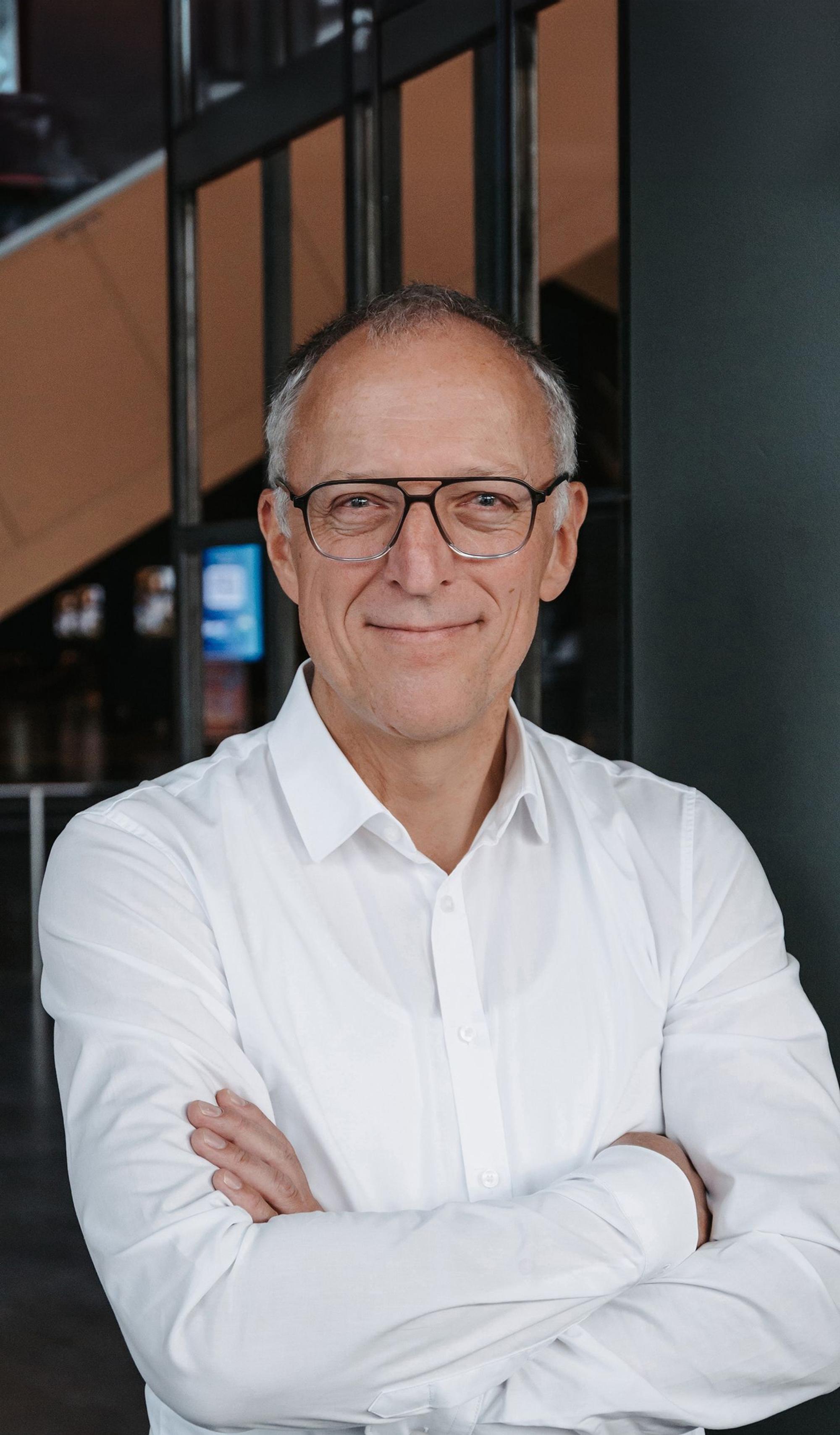 Thomas Benzing lächelt in die Kamera.