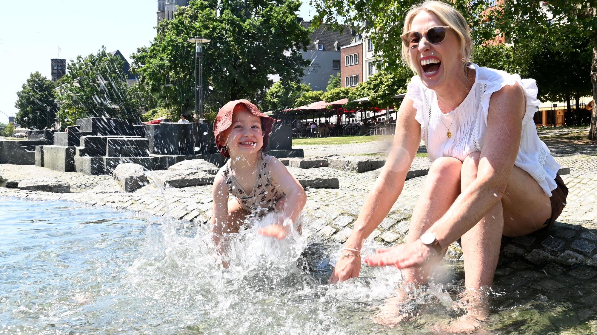 Leon und Mama Kati kühlen sich im Kölner Rheingarten ab.