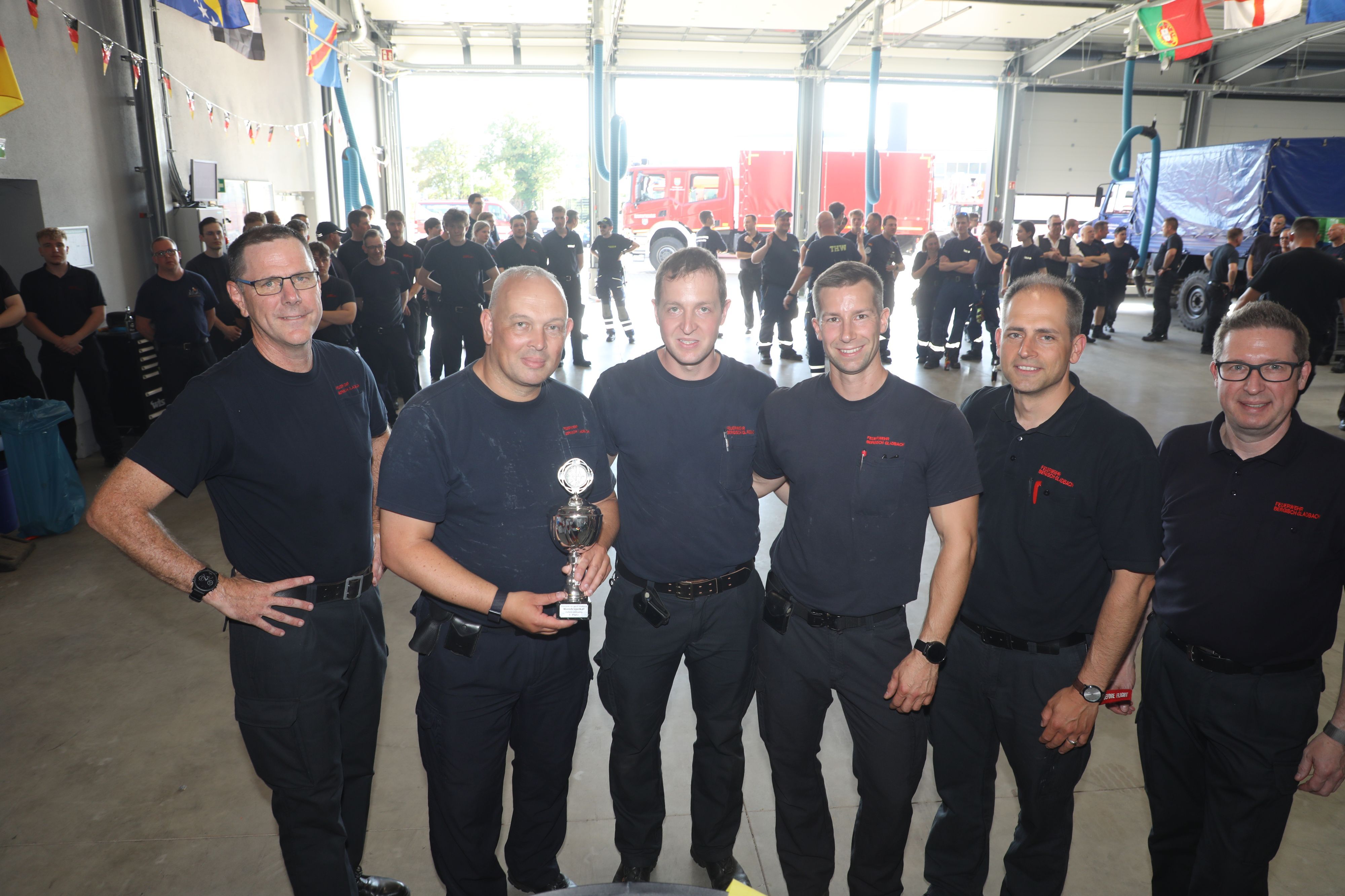Die Sieger halten ihren Wanderpokal und schauen mit Feuerwehrchef Jörg Köhler und seinen Stellvertretern Frank Haag und Benjamin Severin-von Polheim in die Kamera.