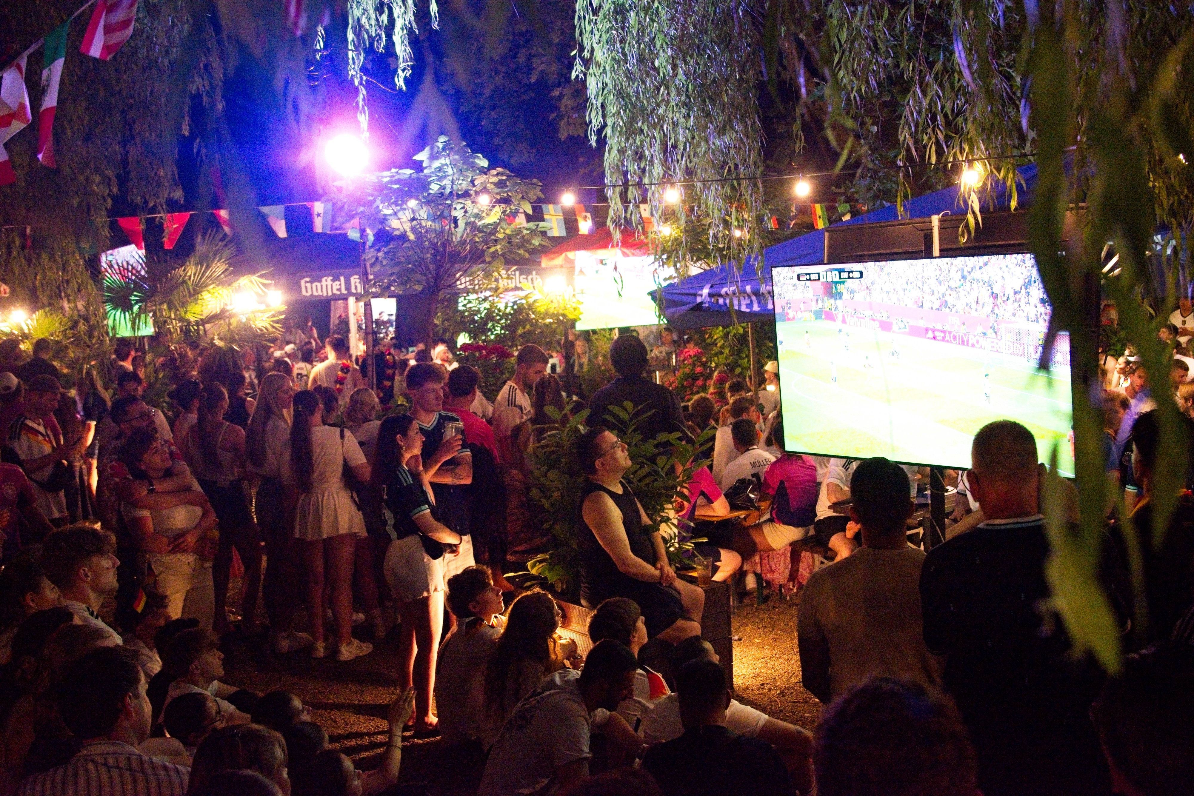 Fans schauen das Spiel gegen die Elfenbeinküste im Biergarten am Aachener Weiher.