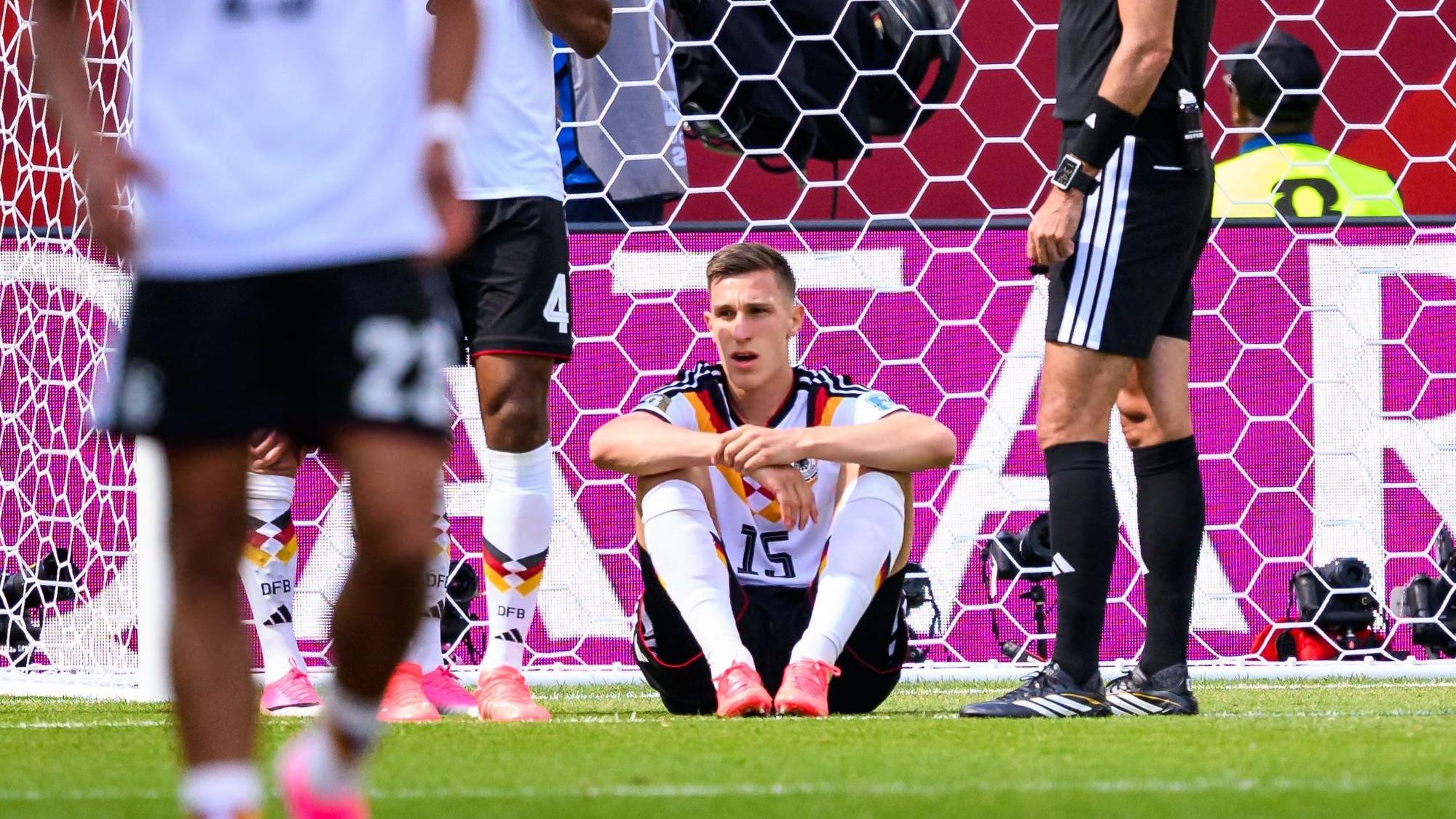 Nico Schlotterbeck sitzt nach einem Zweikampf verletzt auf dem Rasen.
