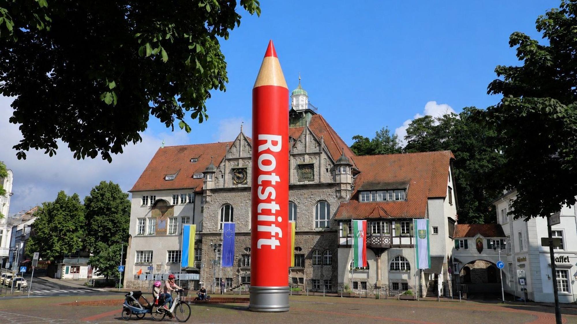 Das Bild zeigt einen großen Rotstift vor dem Rathaus in Bergisch-Gladbach.