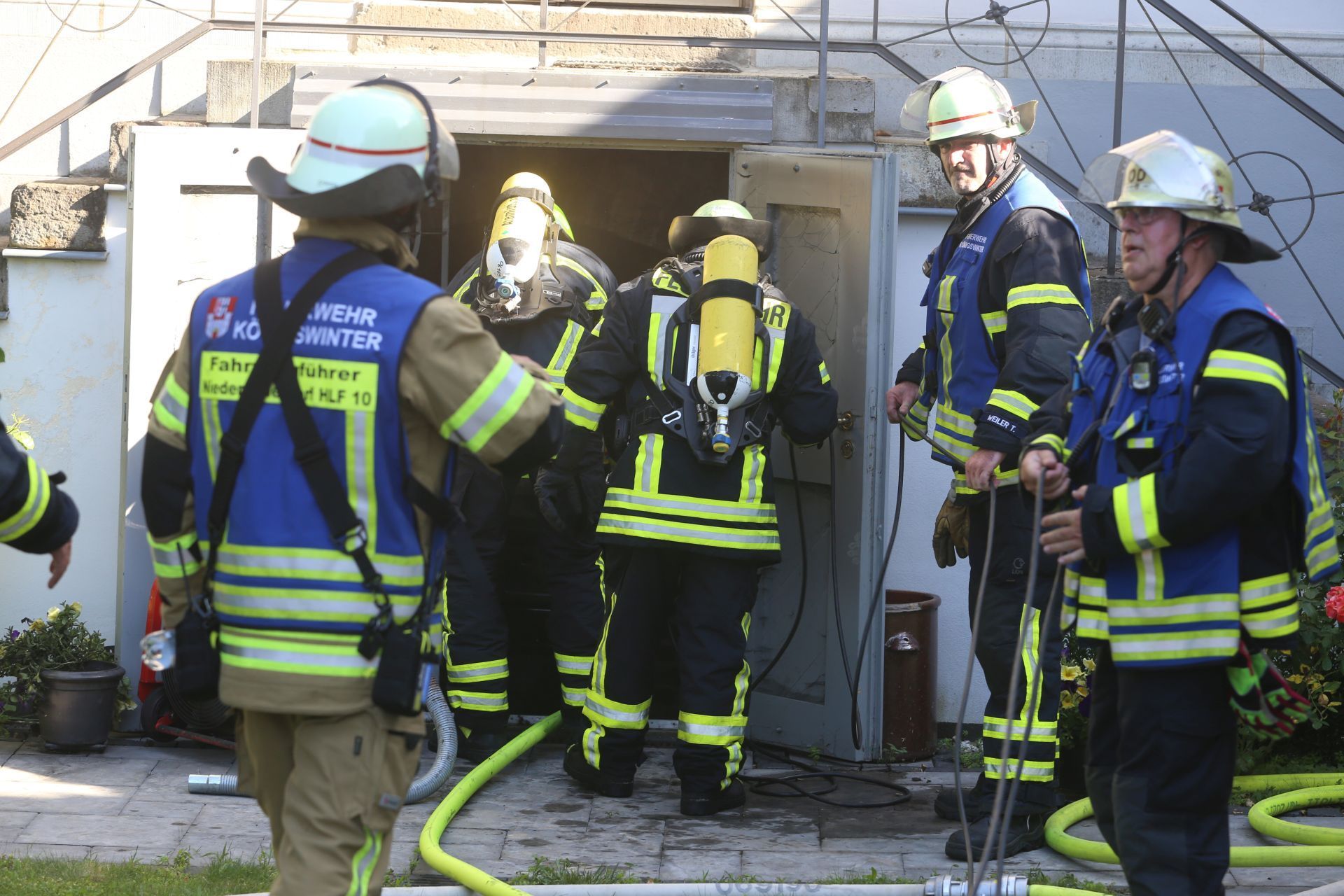 Eine Gruppe von Feuerwehrleuten, zwei von ihnen tragen Atemschutzgeräte.