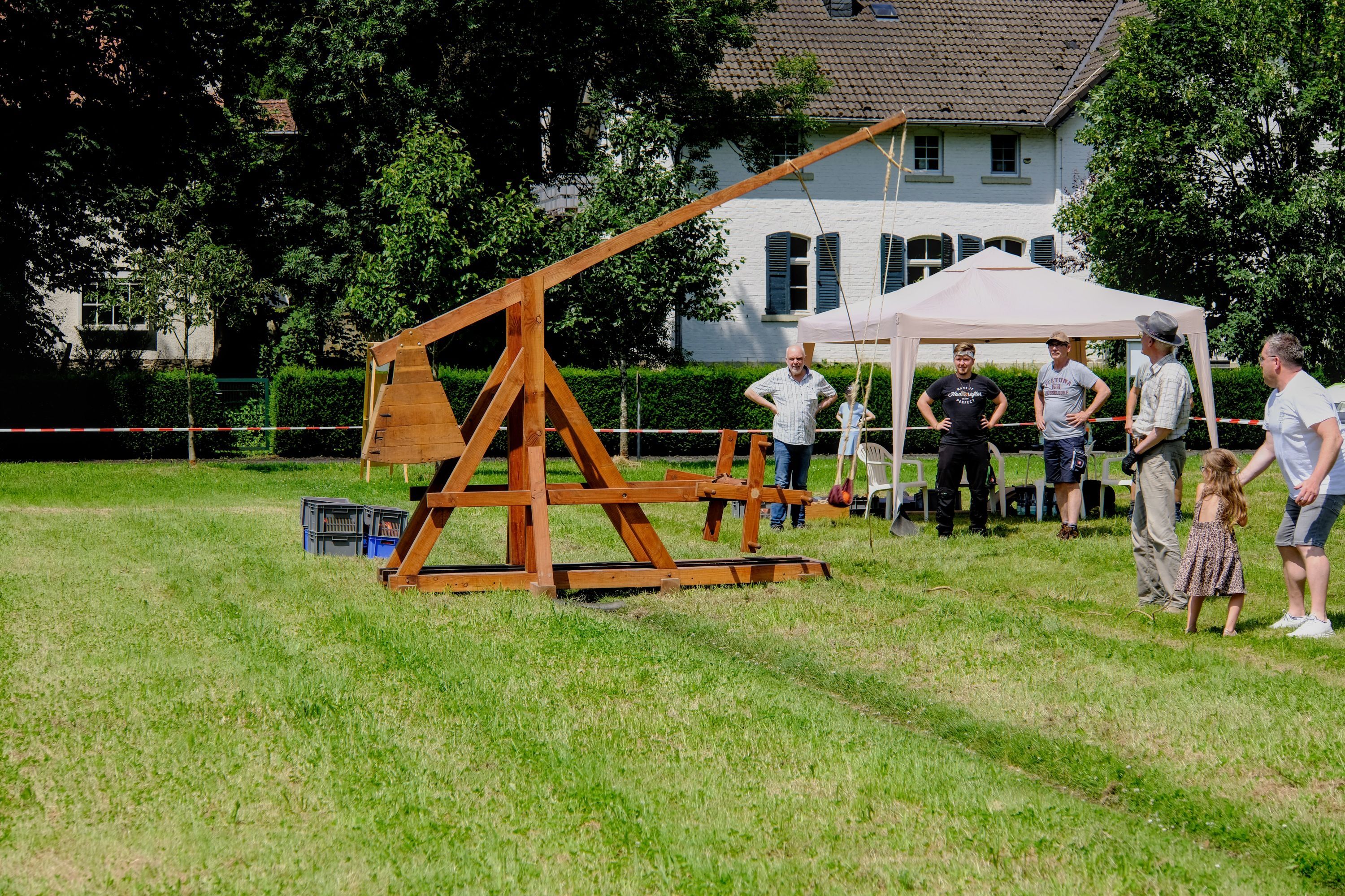 Eine Wurfmaschine aus Holz steht auf Rasen.
