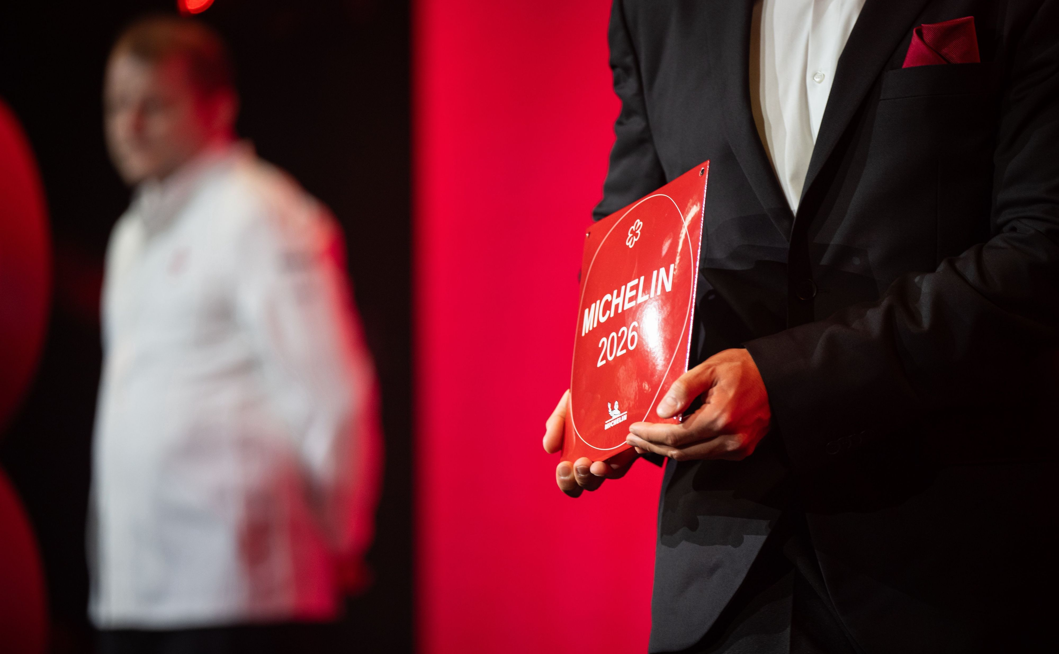 Ein Mitarbeiter hält ein 1-Sterne-Michelin-Schild in den Händen. Mit den Guide-Michelin-Sternen werden jährlich die besten Restaurants Deutschlands ausgezeichnet.