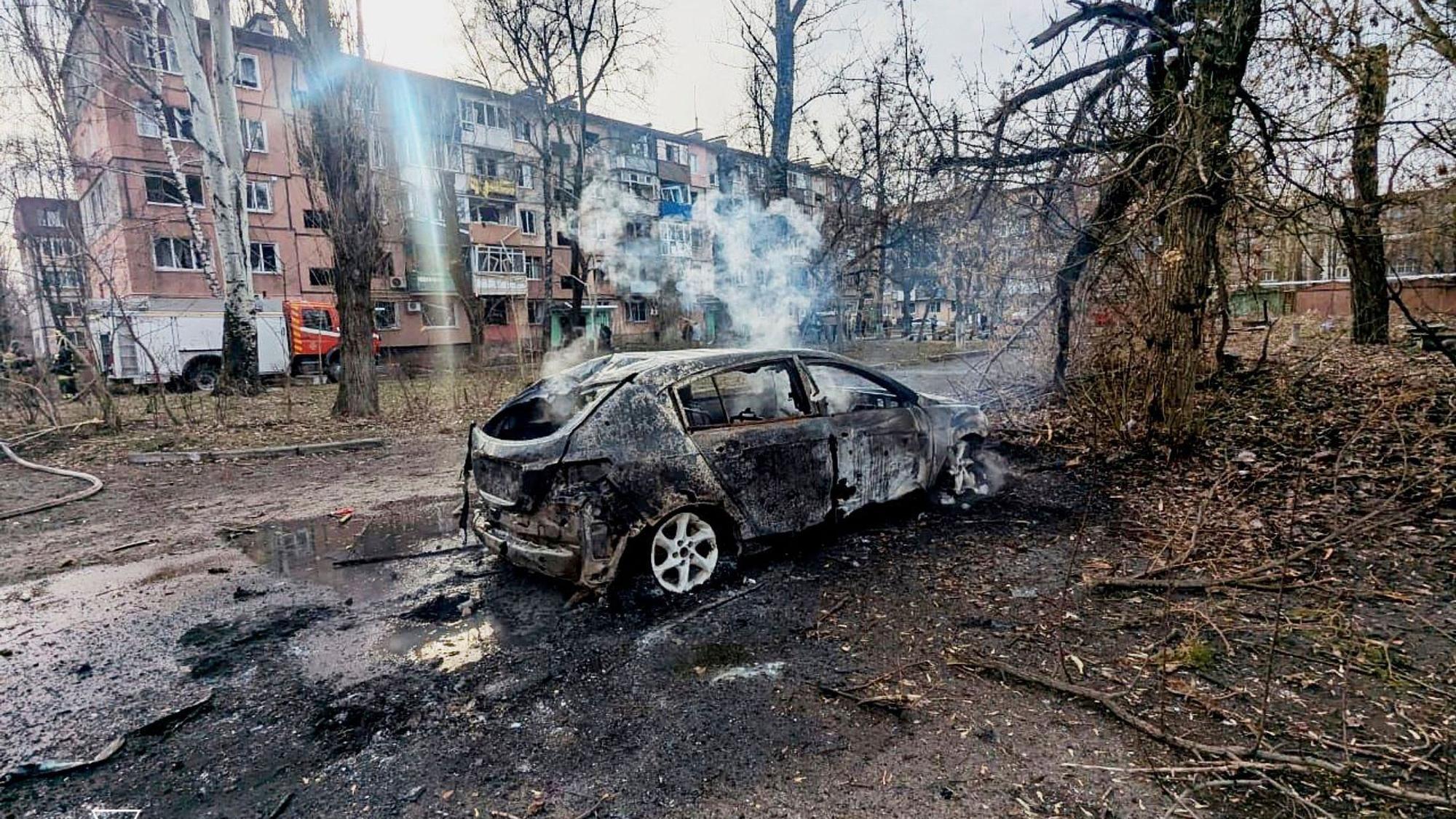 Auf diesem vom ukrainischen Katastrophenschutz zur Verfügung gestellten Foto sind ein verbranntes Auto und beschädigte Wohnhäuser in Krywyj Rih zu sehen, nachdem eine russische Rakete eingeschlagen ist.