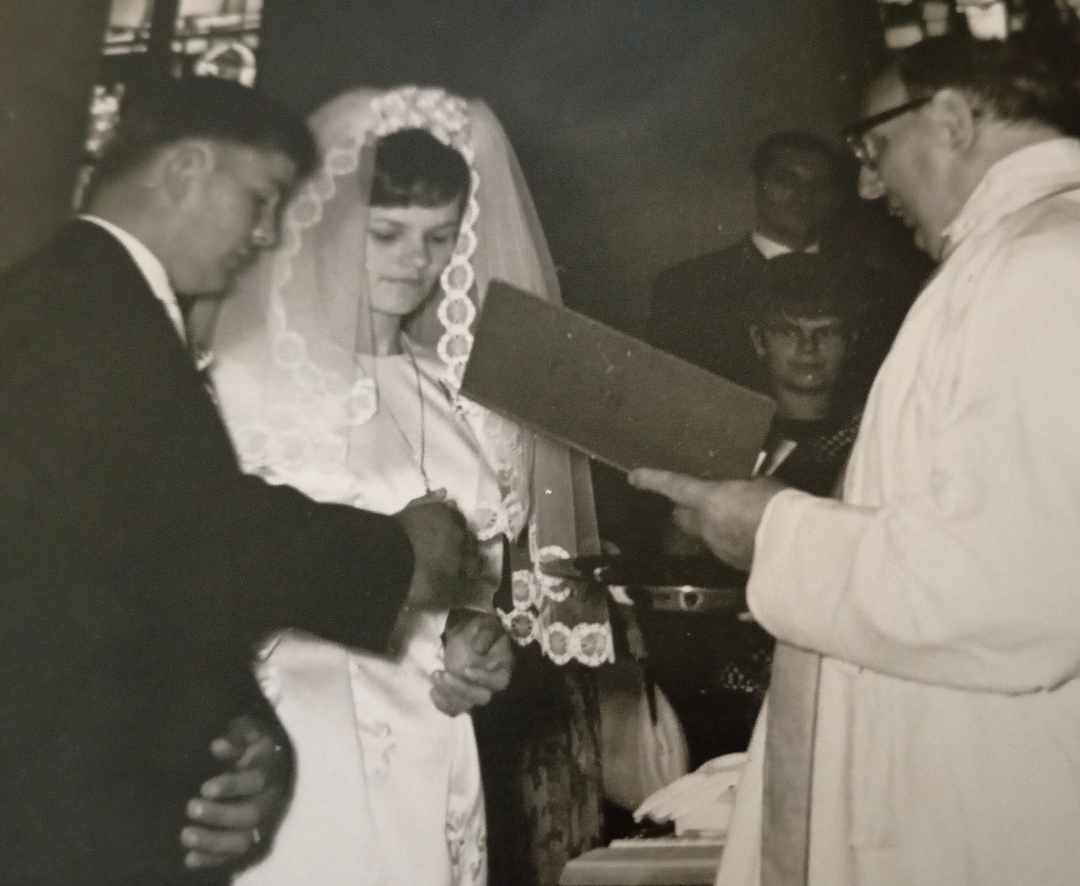 Das schwarz-weiß Foto zeigt die beiden bei der Hochzeit, vor ihnen steht ein Pfarrer.