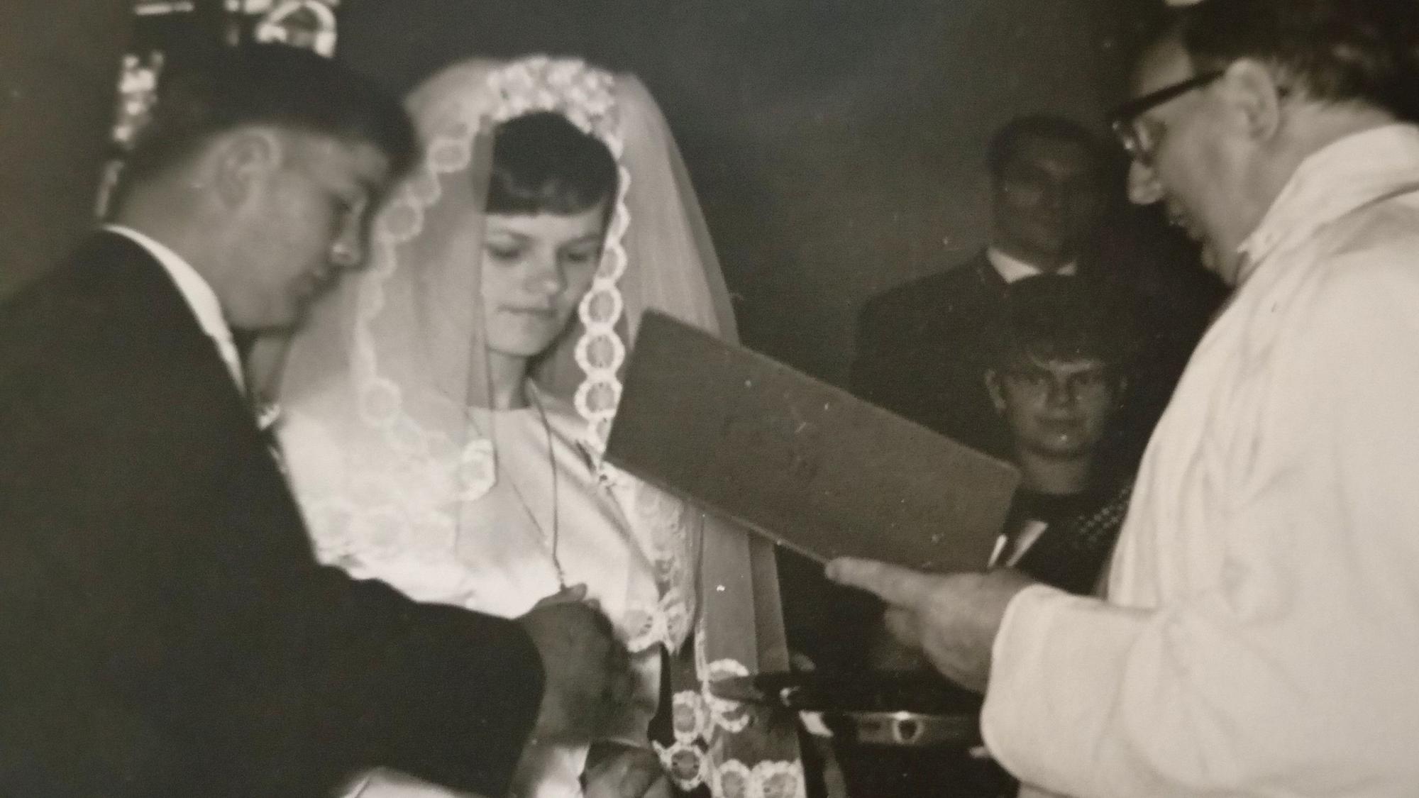 Das schwarz-weiß Foto zeigt die beiden bei der Hochzeit, vor ihnen steht ein Pfarrer.
