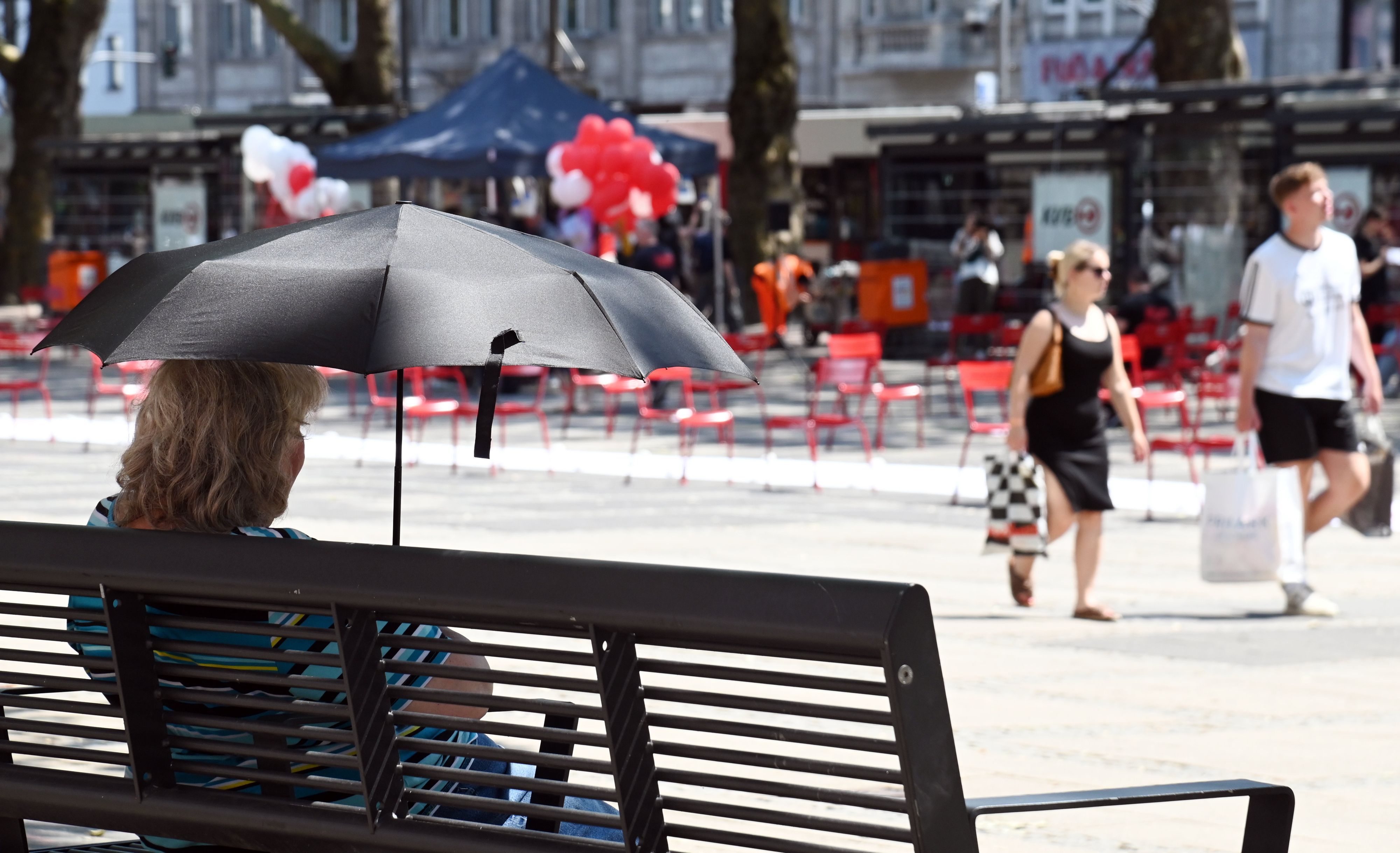 Hitzewelle in Köln: Am Neumarkt suchen die Menschen Abkühlung am Brunnen und im Schatten.
