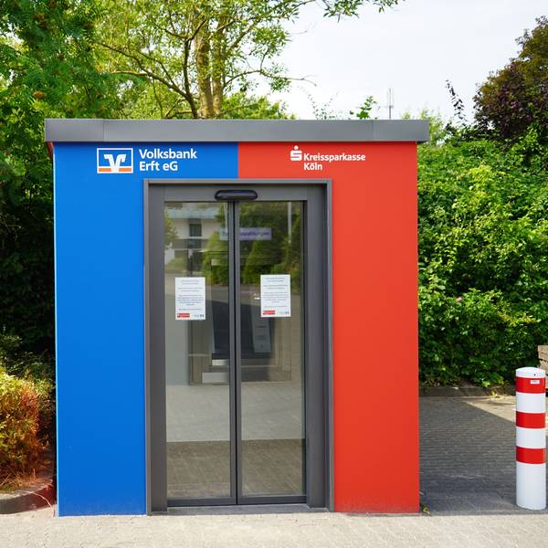Das Bild zeigt den rot-blauen Selbstbedienungs-Pavillon auf dem Aldi-Parkplatz.