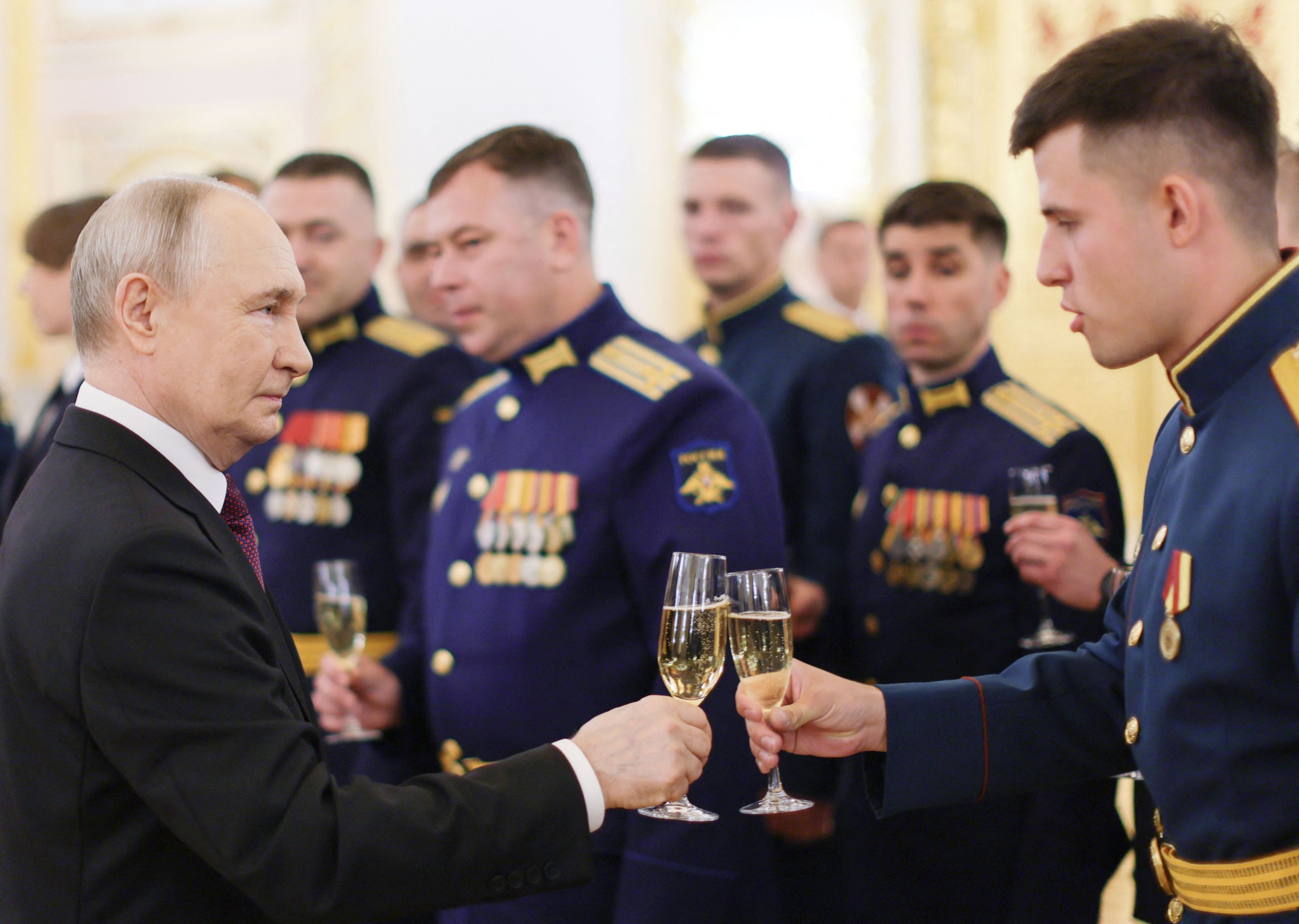 Russlands Präsident Wladimir Putin stößt mit Absolventen der russischen Militärakademien im Kreml an.
