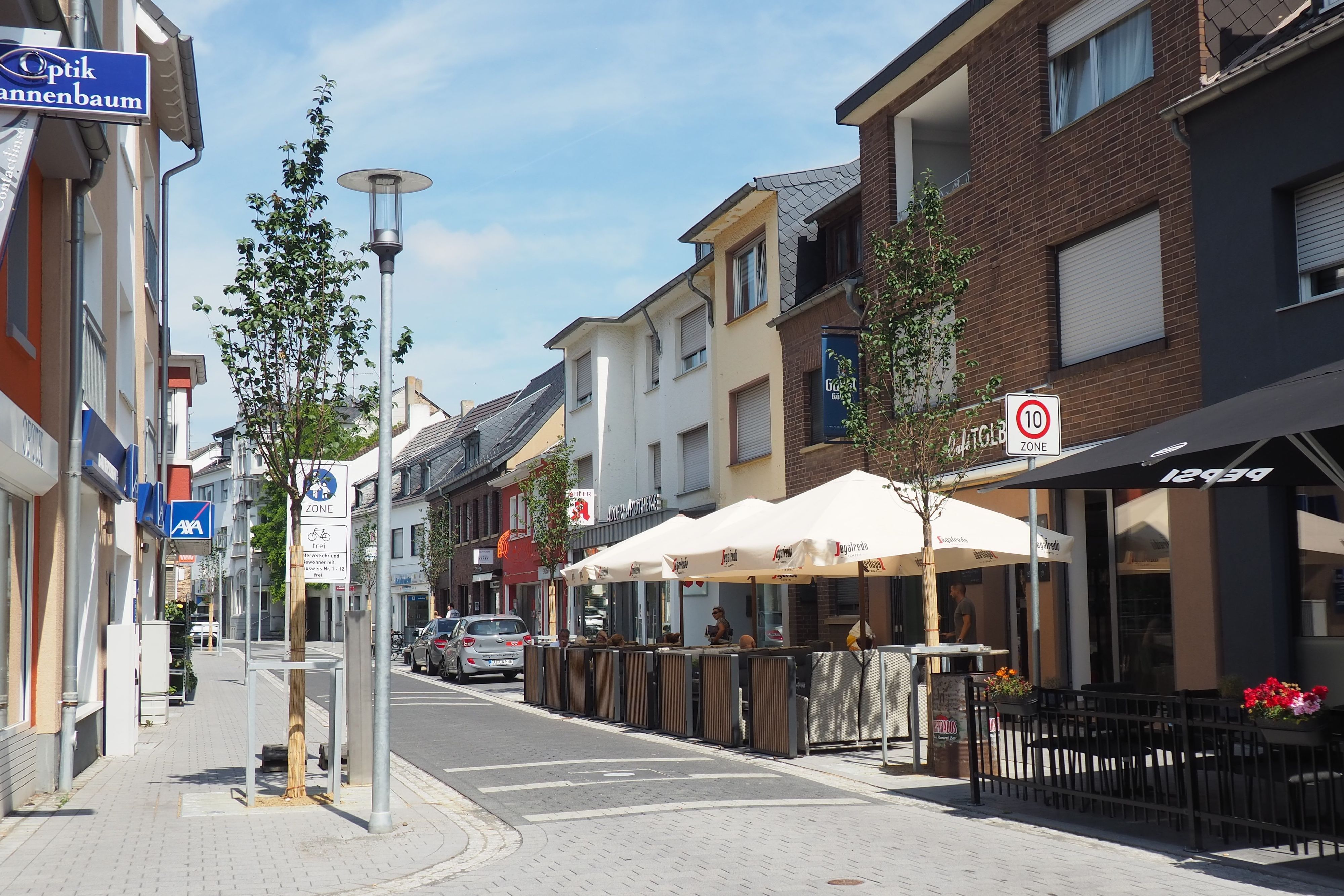 Die Münsterstraße ist mit hellem Pflaster versehen und wird von Bäumen gesäumt.