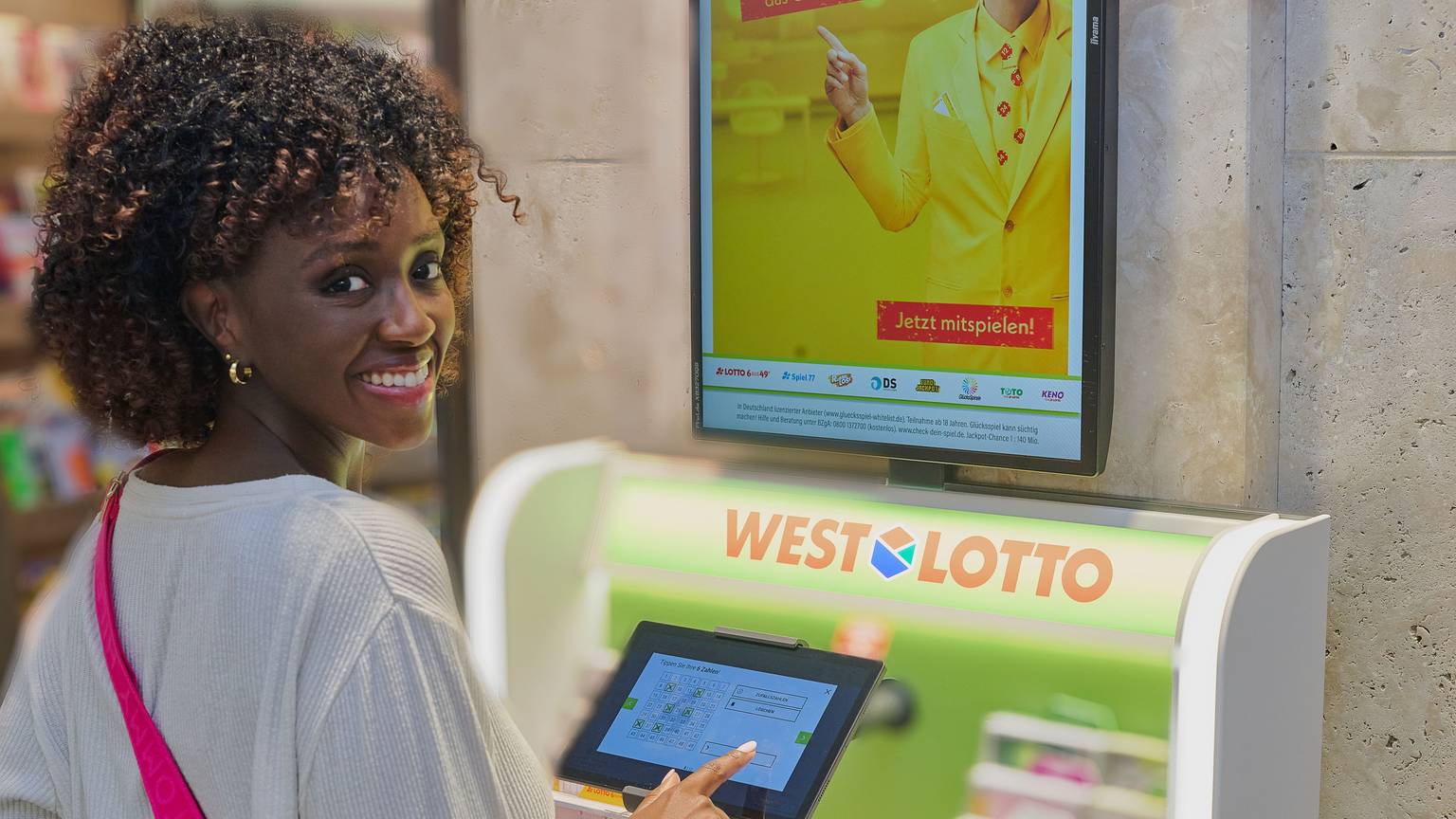 Eine Frau steht vor einem WestLotto-Schalter.