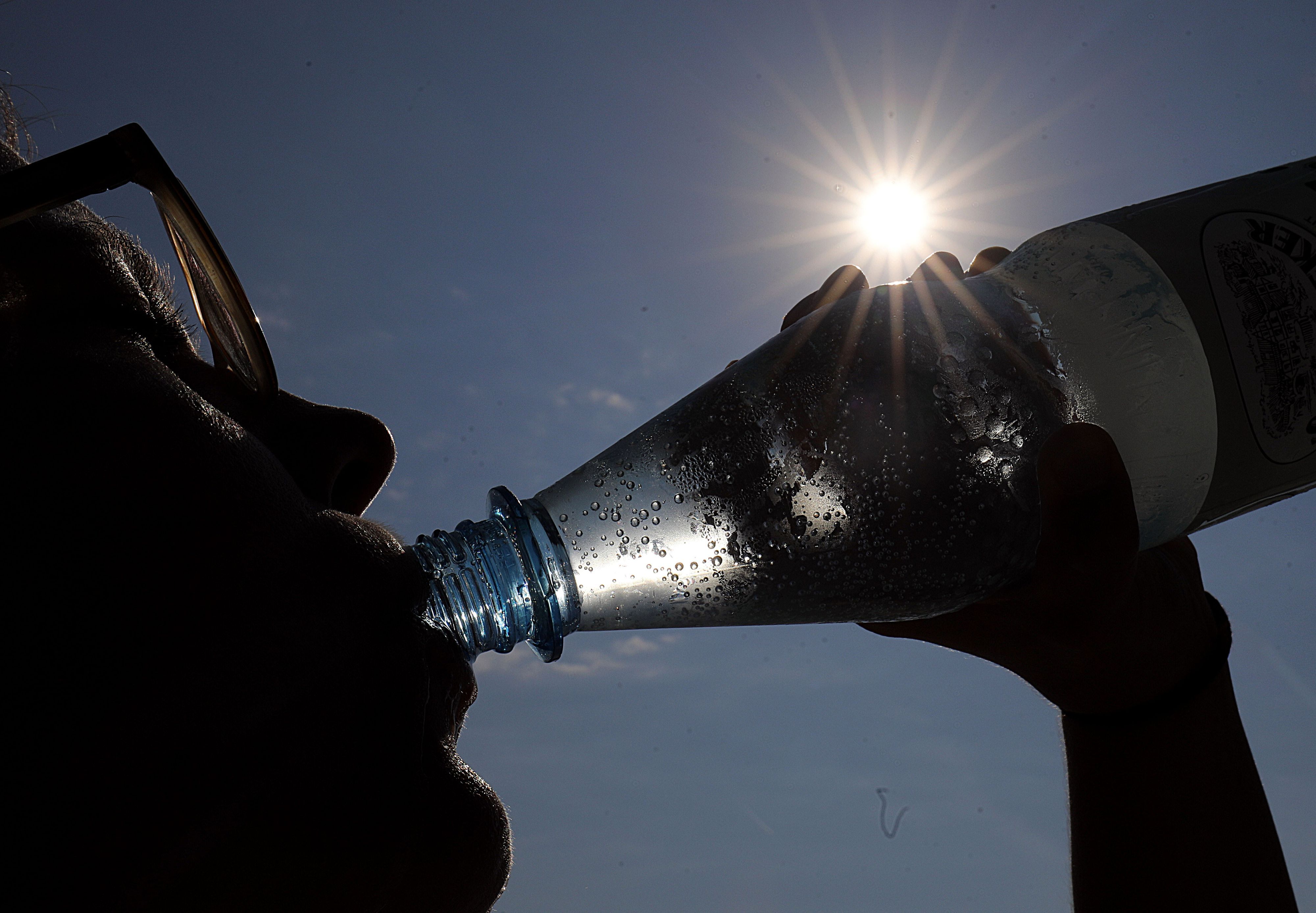 Eine Frau trinkt in Köln in der Sonne Mineralwasser. (Archivbild)