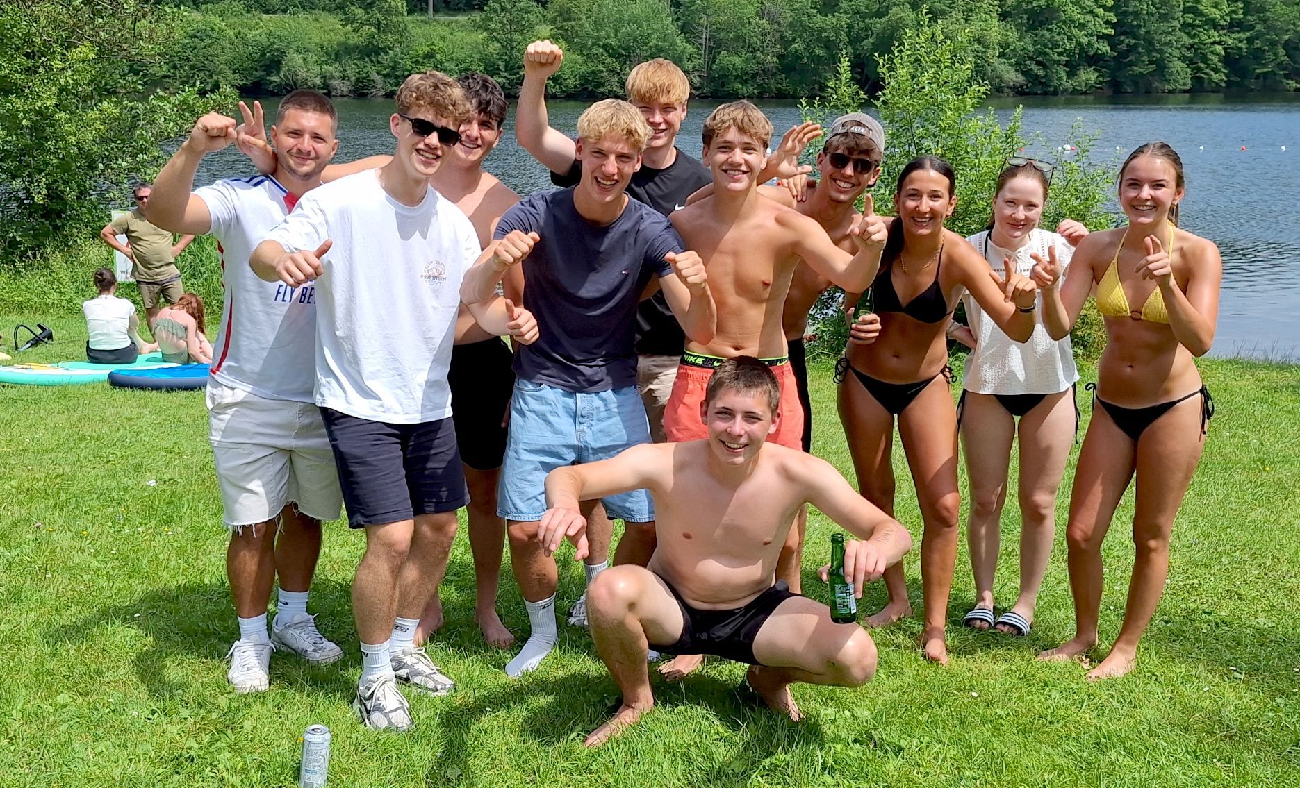 Eine Gruppe Jugendlicher posiert am Seeufer fürs Foto.
