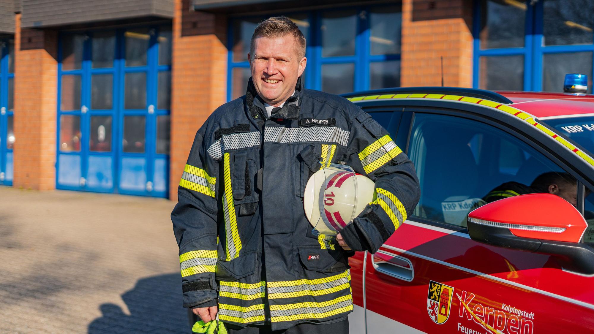 Das Foto zeigt einen Feuerwehrmann mit Helm in der Hand.