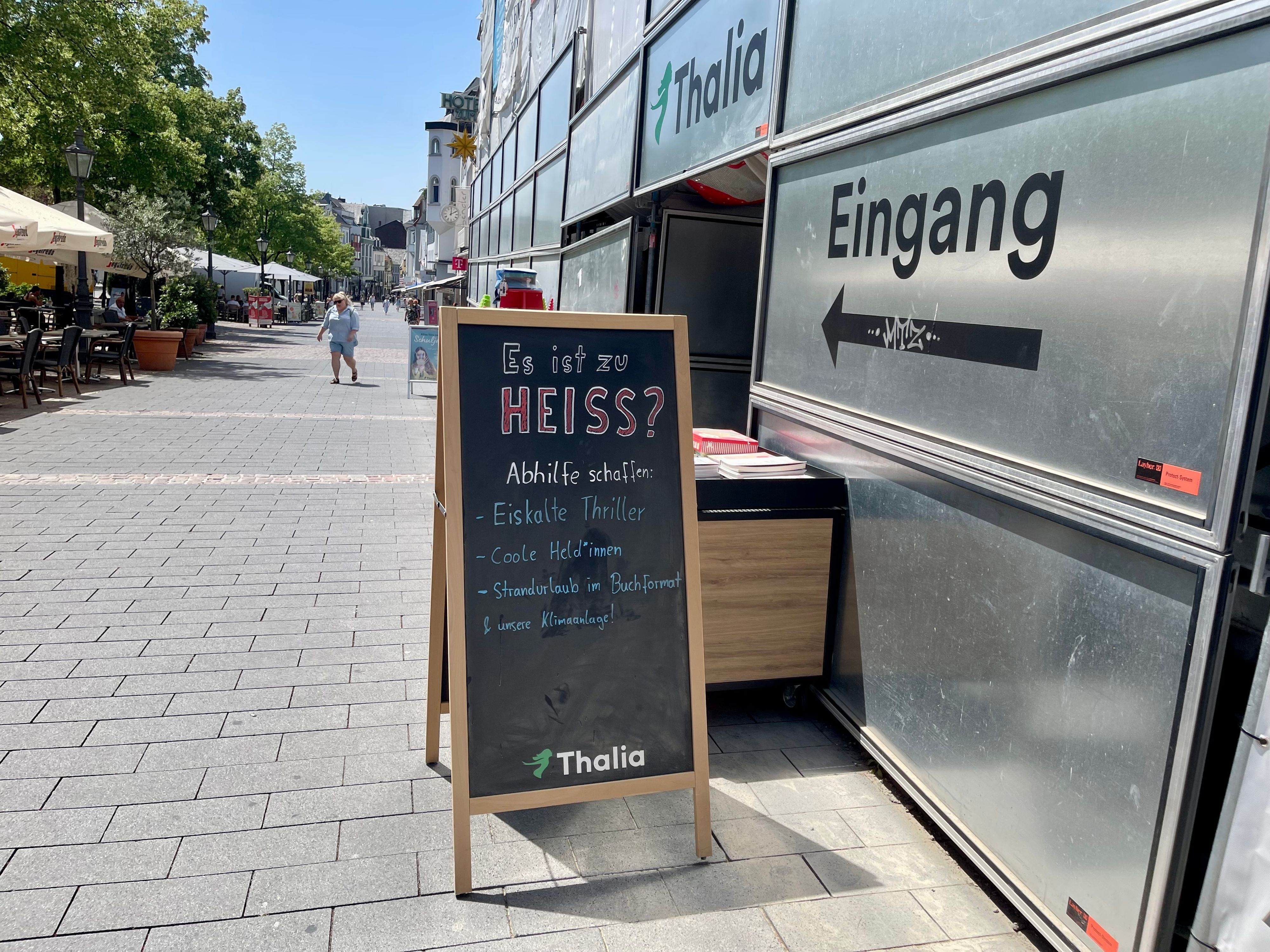 In der Siegburger City reagieren Geschäftsleute auf die Hitze: Die Thalia Buchhandlung lockt mit einer Klimaanlage und eiskalten Thrillern.