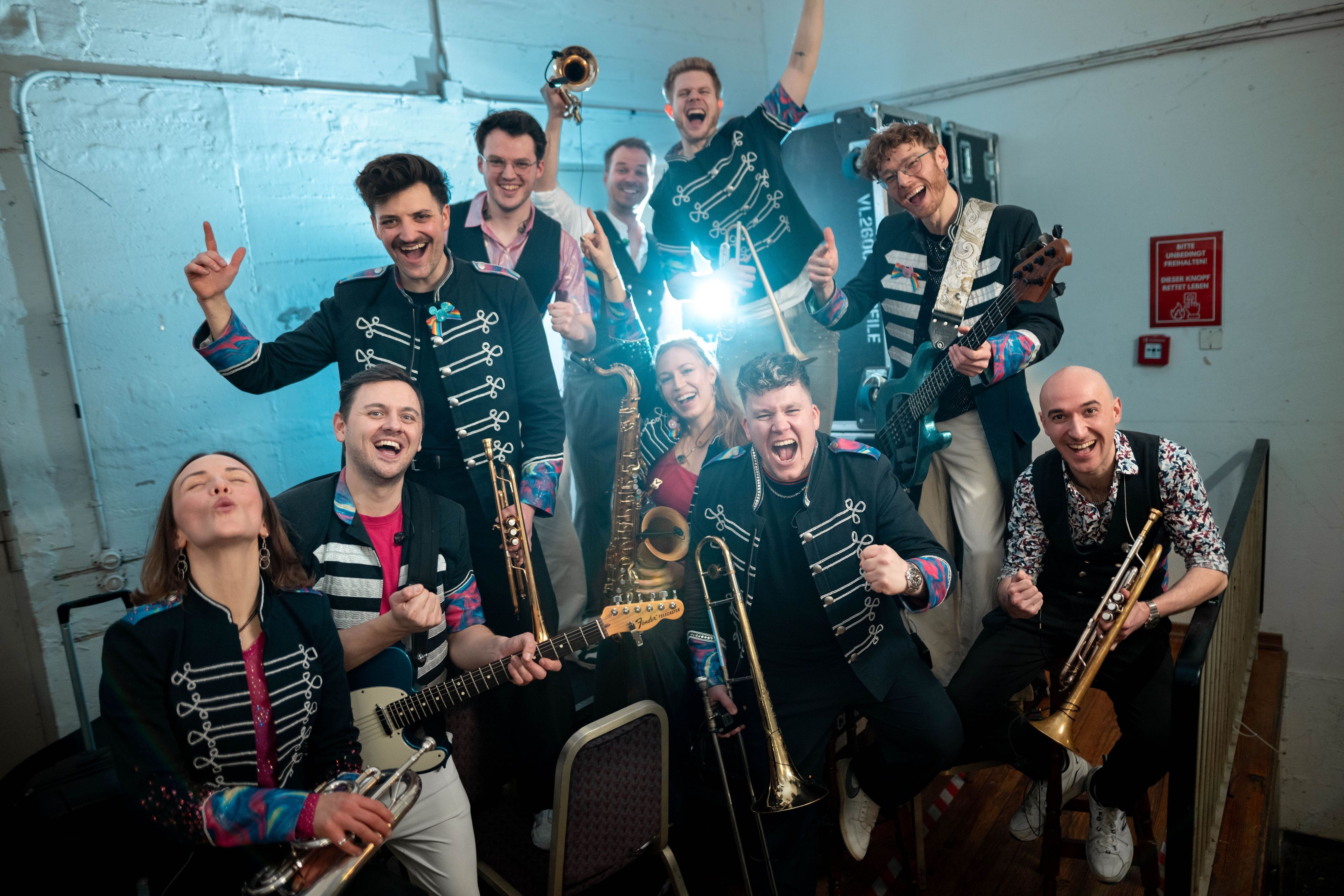 Die Band Druckluft steht zu einem Pressefoto hinter der Bühne.