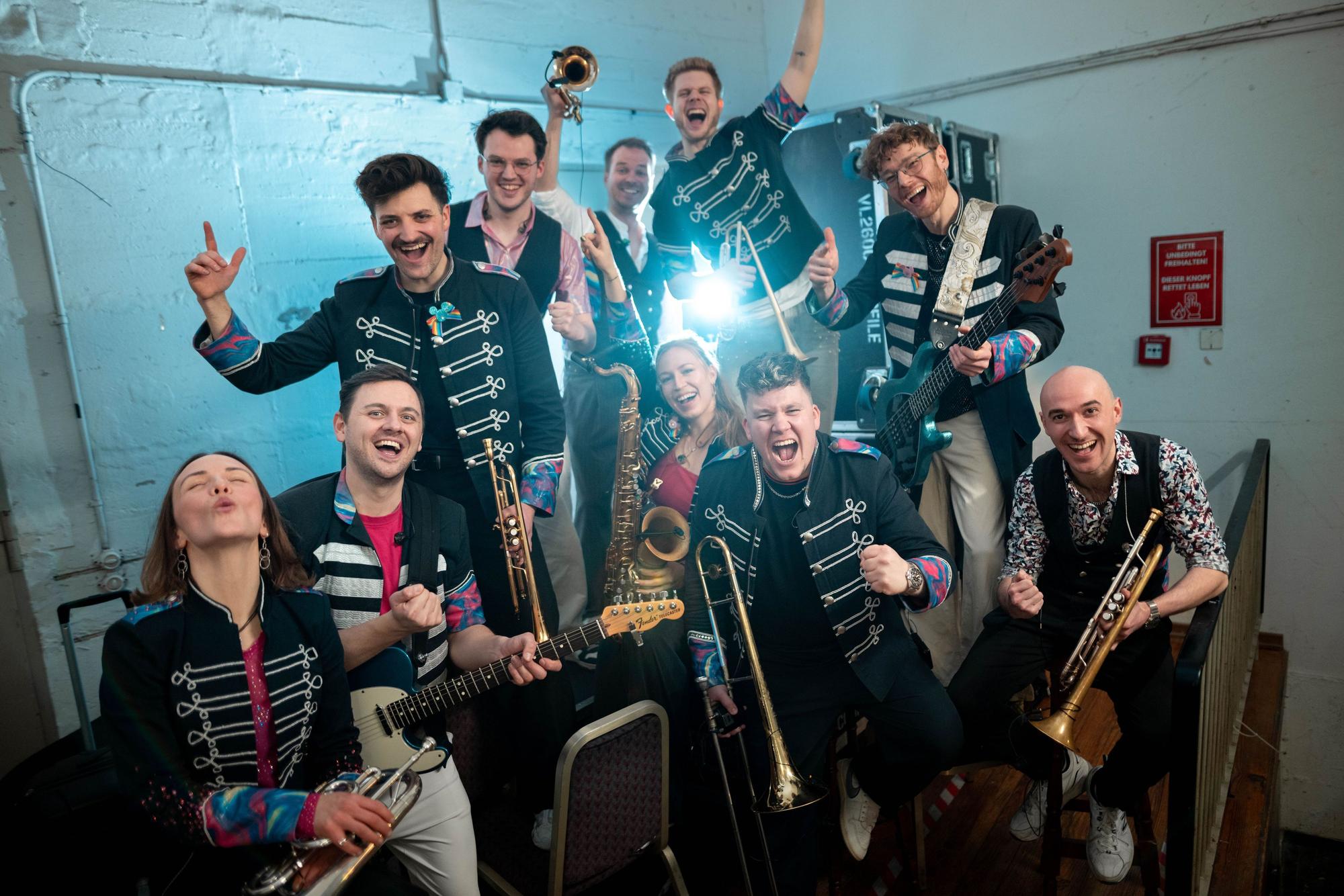 Die Band Druckluft steht zu einem Pressefoto hinter der Bühne.