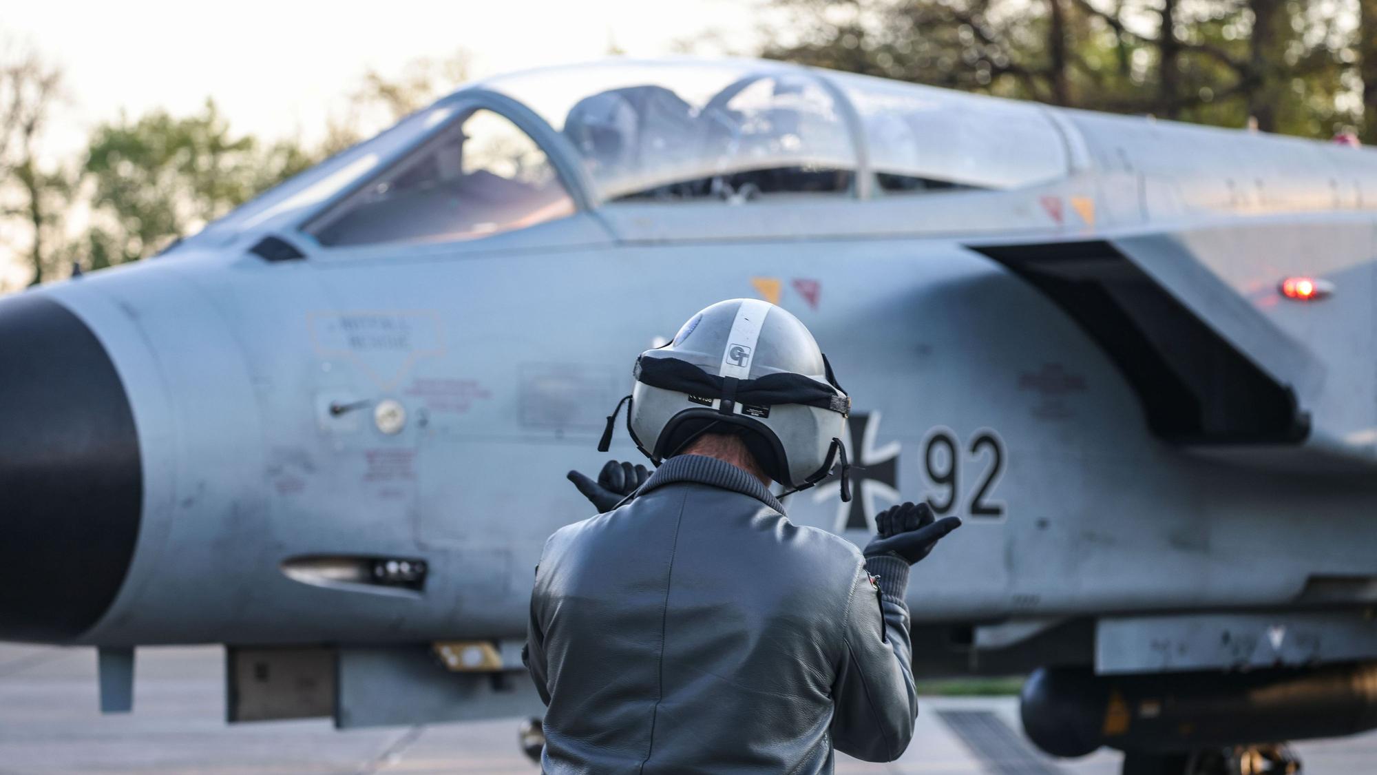 Auf dem Foto zu sehen ist ein Mann von hinten, der vor einem Tornado-Jet steht.