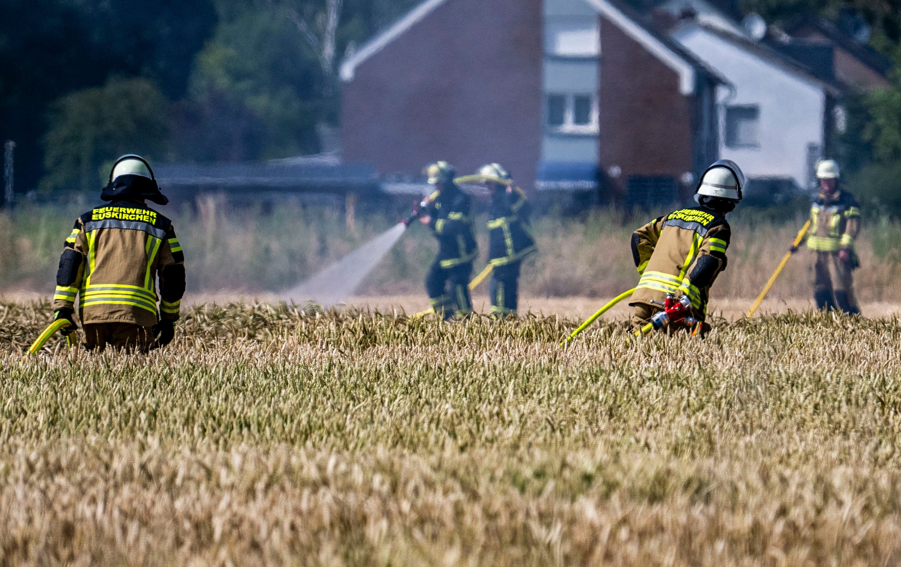 Das Bild zeigt Feuerwehrleute, die löschen. Und welche, die sich auf dem Weg zum Einsatzort befinden.