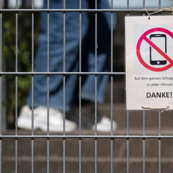 Ein Schild mit einem durchgestrichenen Smartphone und der Aufschrift „Auf dem ganzen Schulgelände – zu jeder Uhrzeit! DANKE!“ hängt am Zugangstor zum Schulhof eines Gymnasiums und weist auf ein generelles Handyverbot hin. Auch dazu hat Karin Prien konkrete Forderungen. (Archivbild)